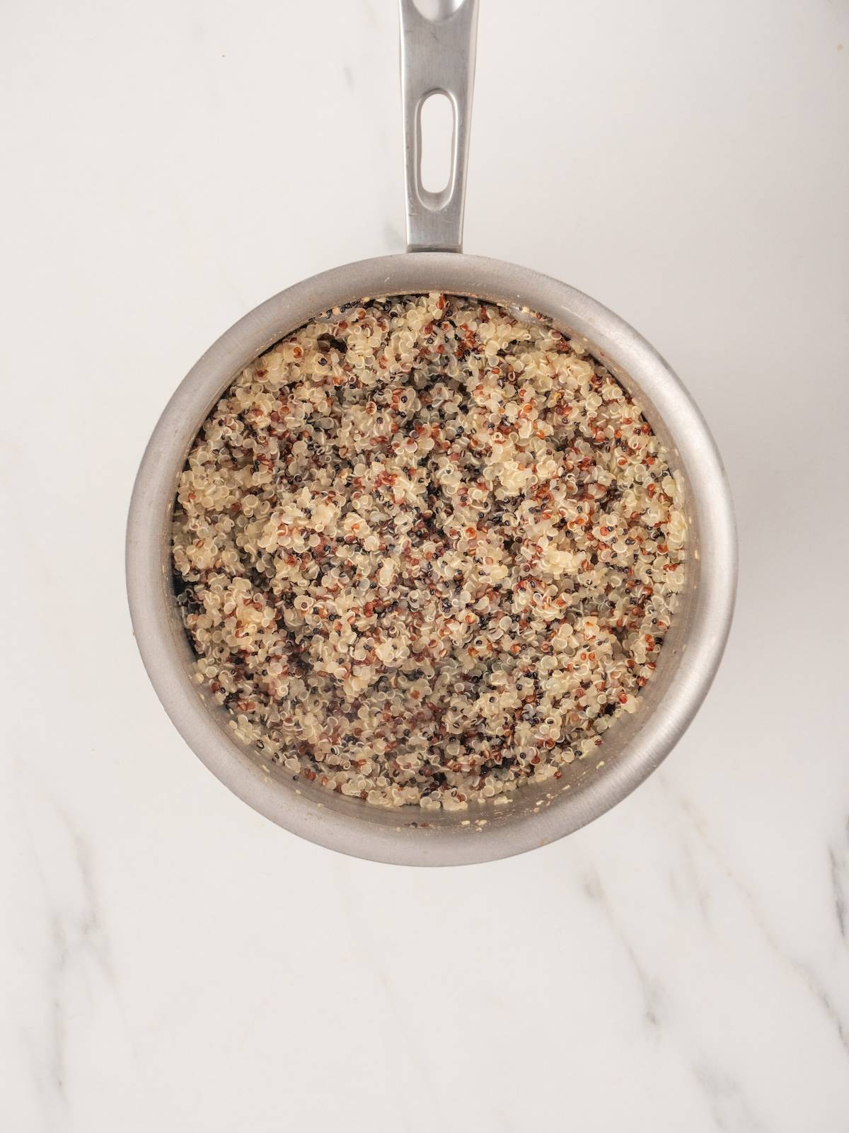 A small saucepan with cooked quinoa.