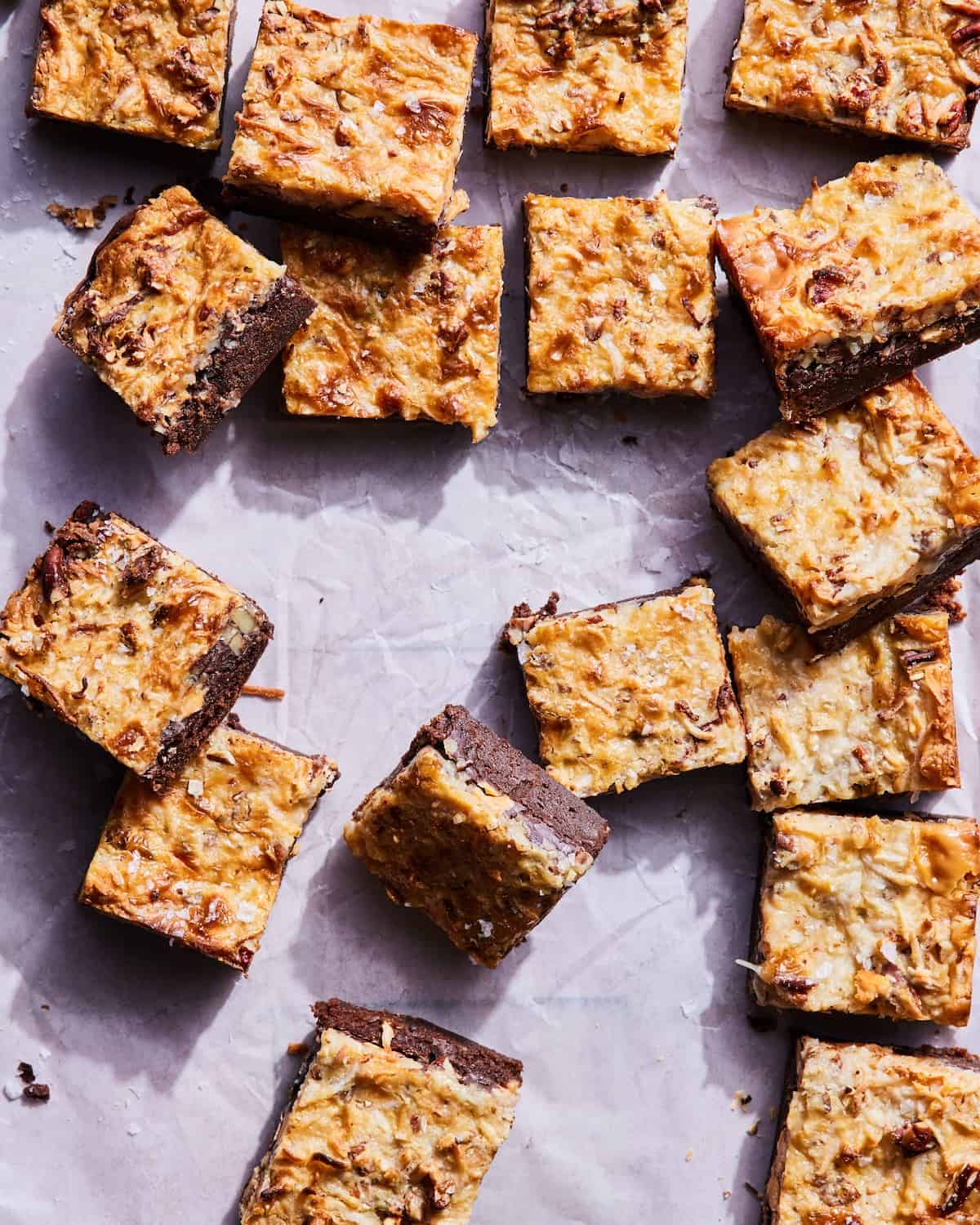Magic Bar Brownies cut into squares on a piece of parchment paper.