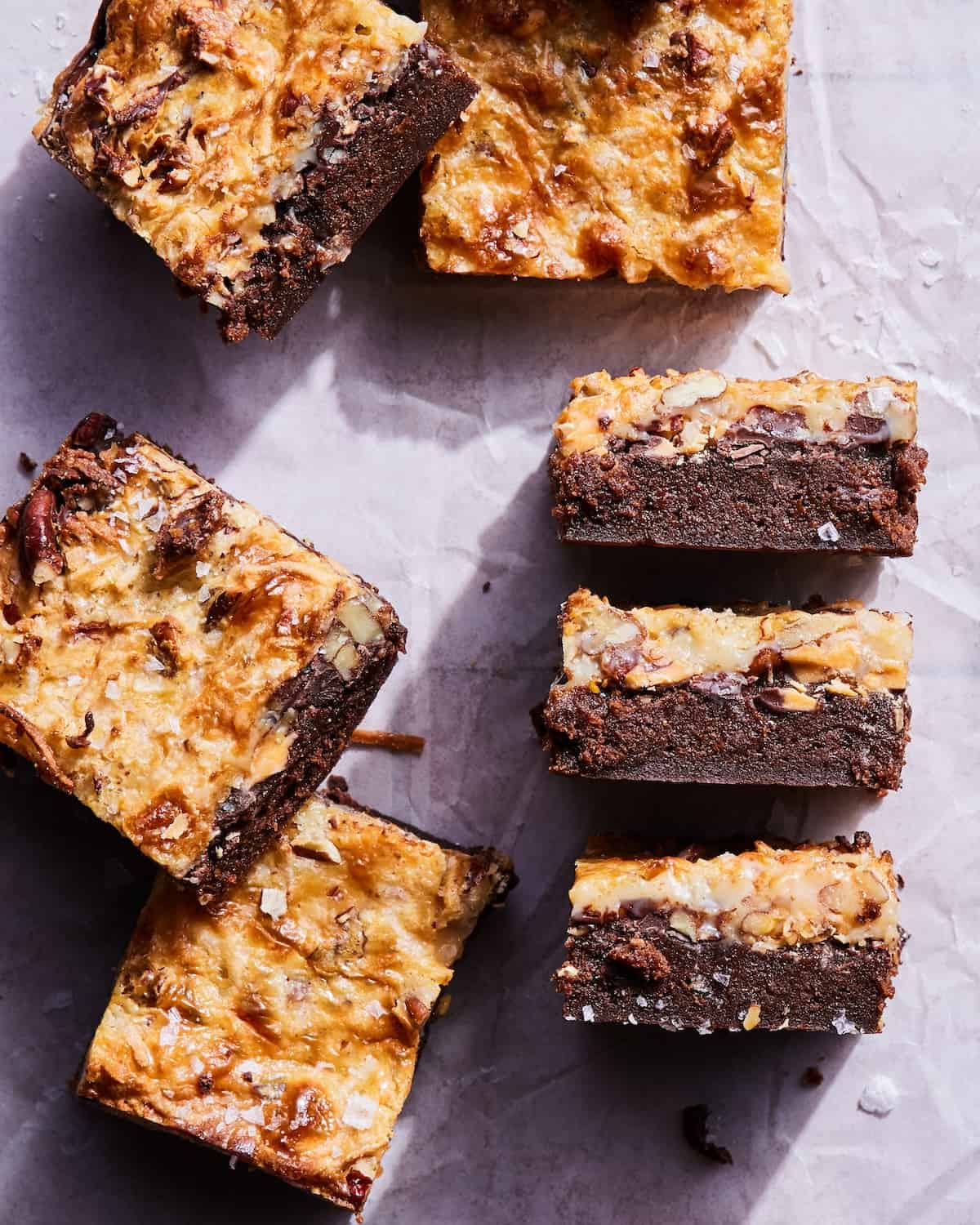 Magic Bar Brownies cut into squares on a piece of parchment paper.