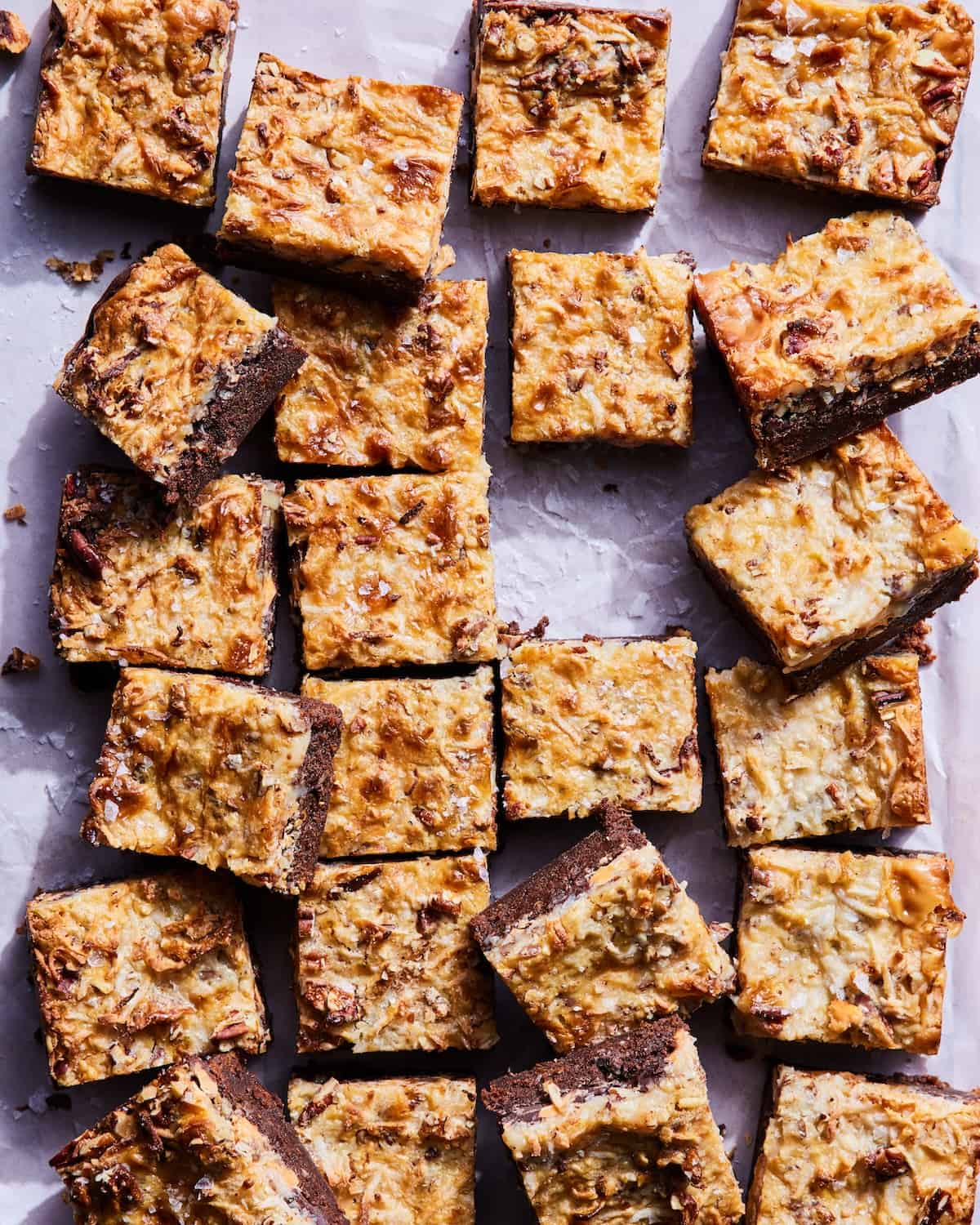 Magic Bar Brownies cut into squares on a piece of parchment paper