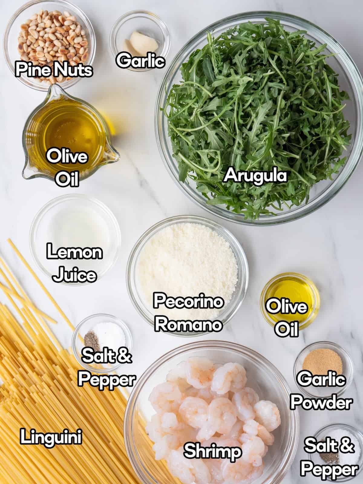 Mise en place of all the ingredients required to make arugula pesto pasta with garlic shrimp.