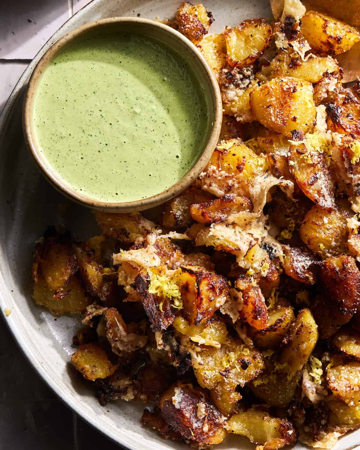 a close up of Crispy Potatoes with Spicy Green sauce on a serving platter