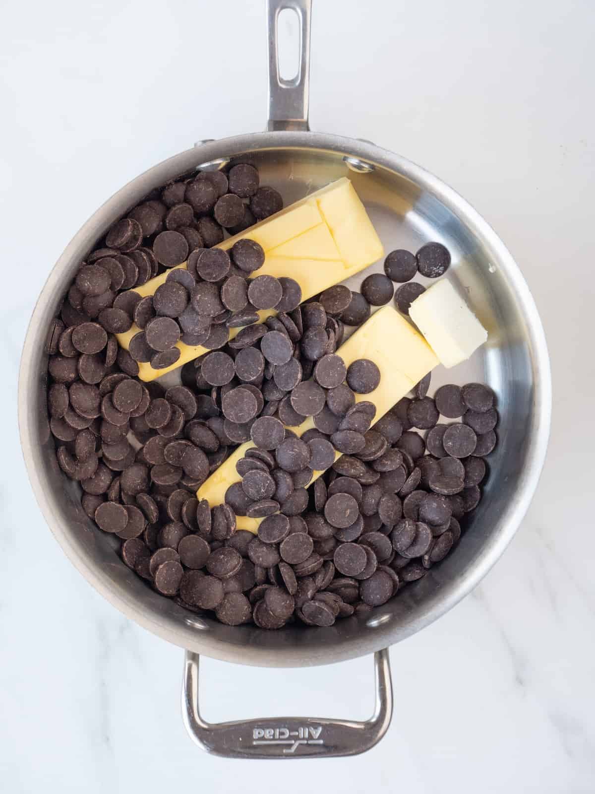 A saucepan with butter and chocolate chips.