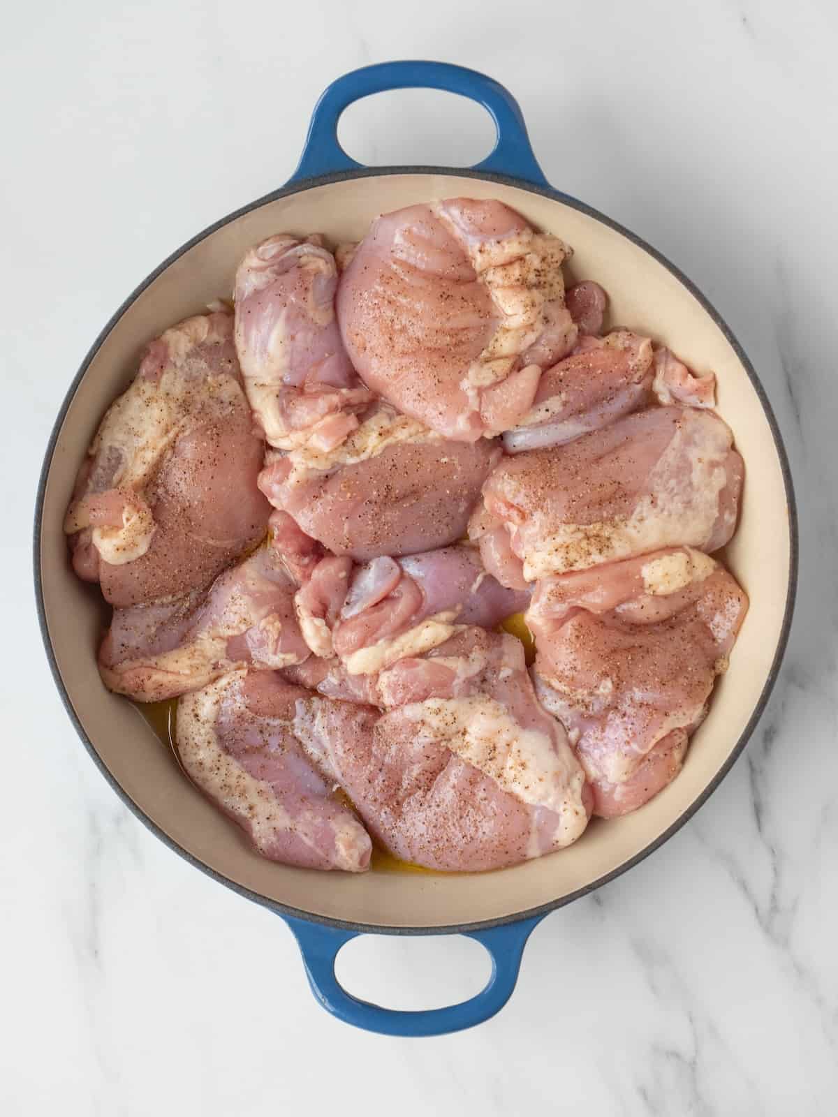 A dutch oven with chicken thighs being cooked.