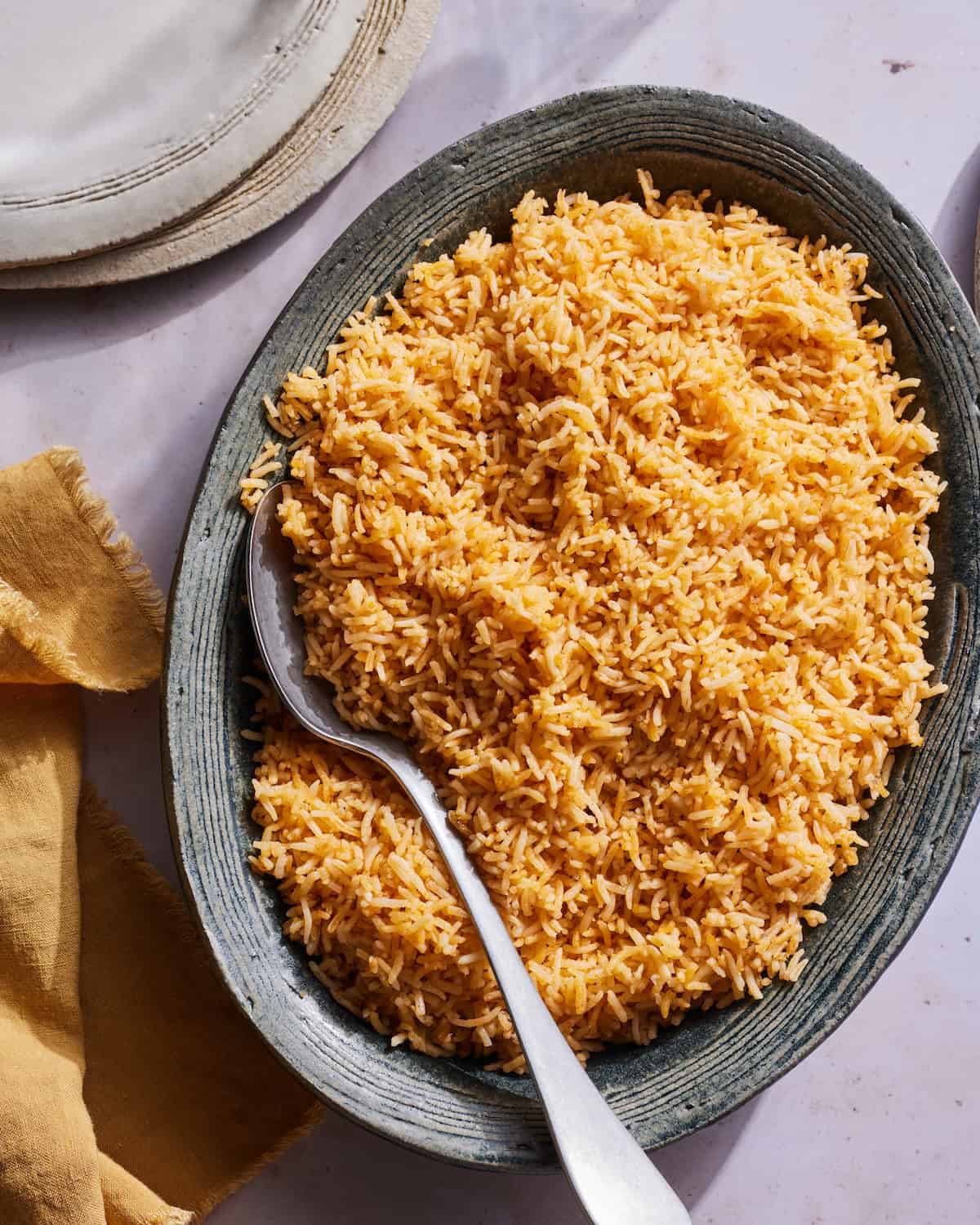Spanish Rice in a serving bowl with a serving spoon.