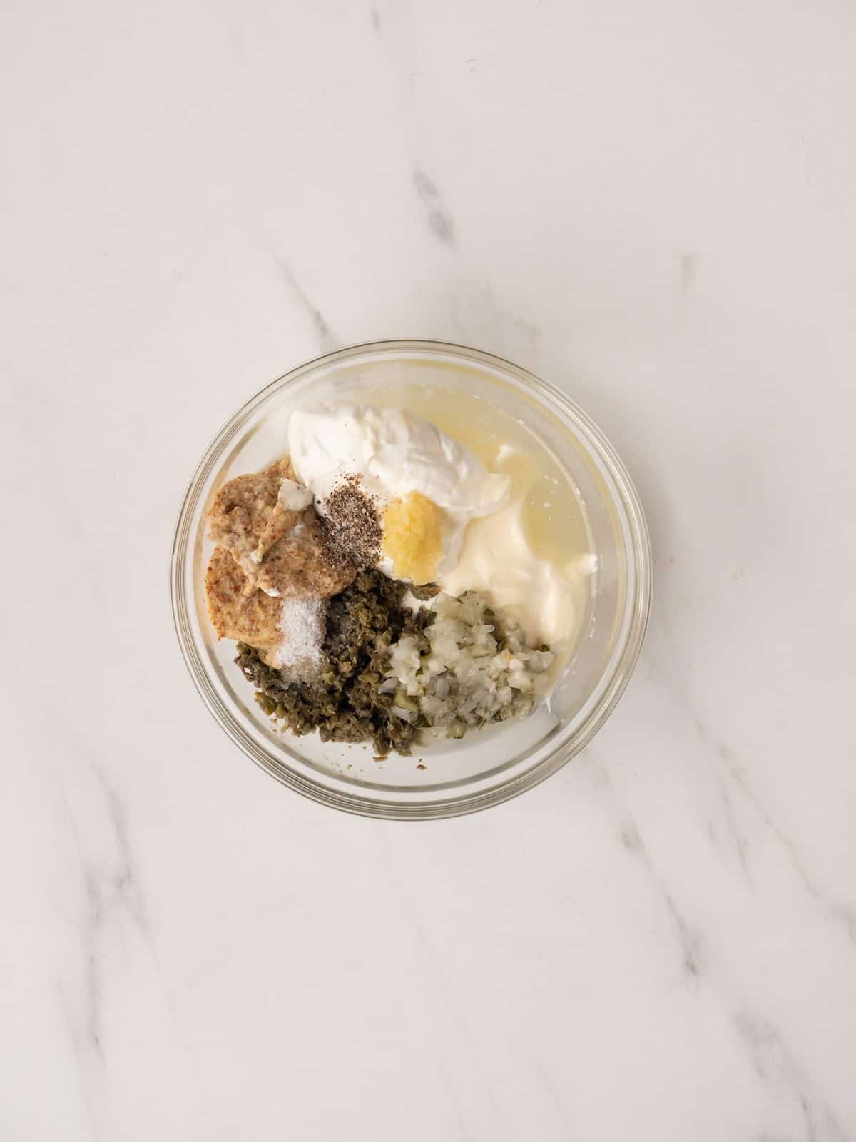 A small glass mixing bowl to make a creamy caper dipping sauce.