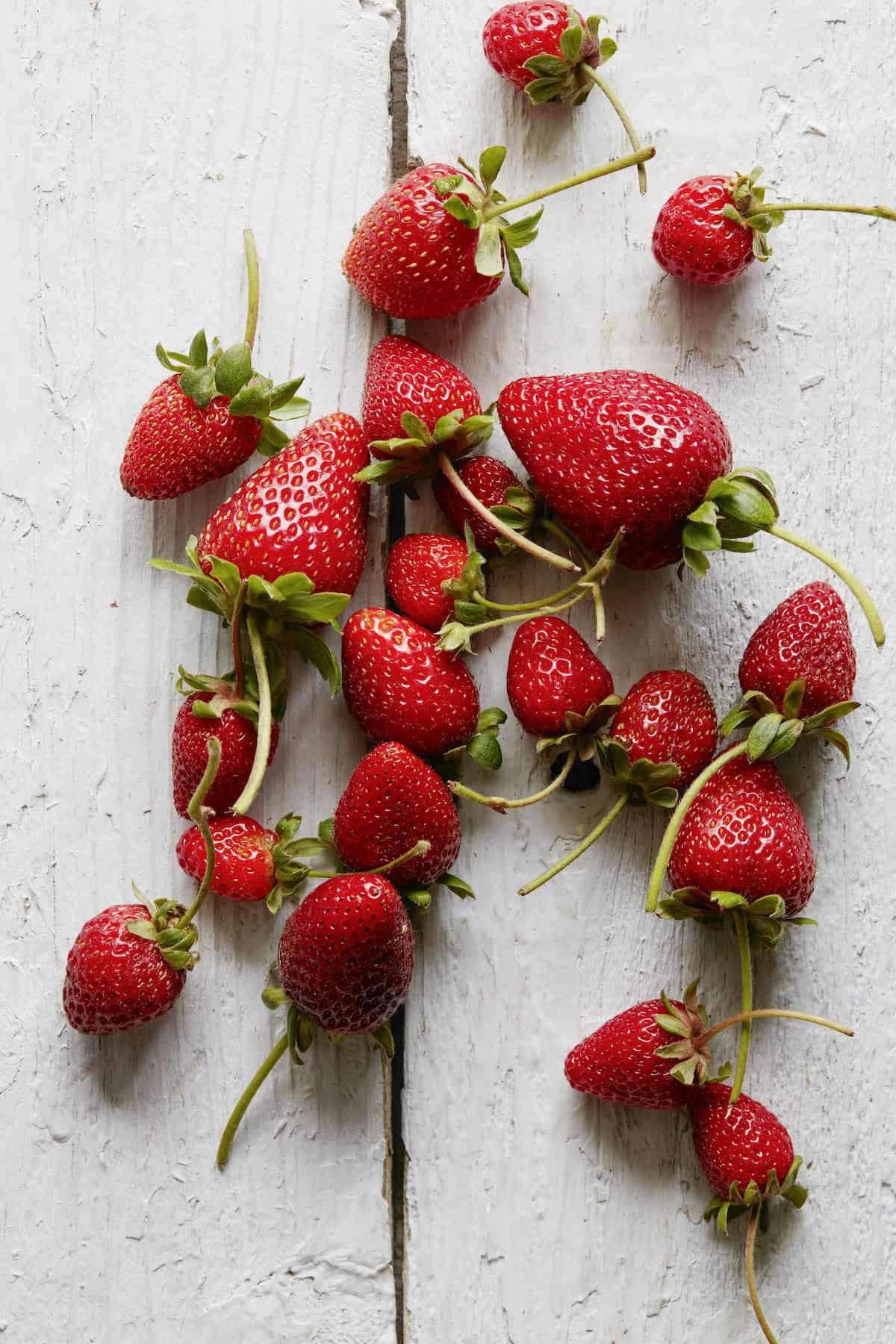 An overhead shot of strawberries on a wooden table top.