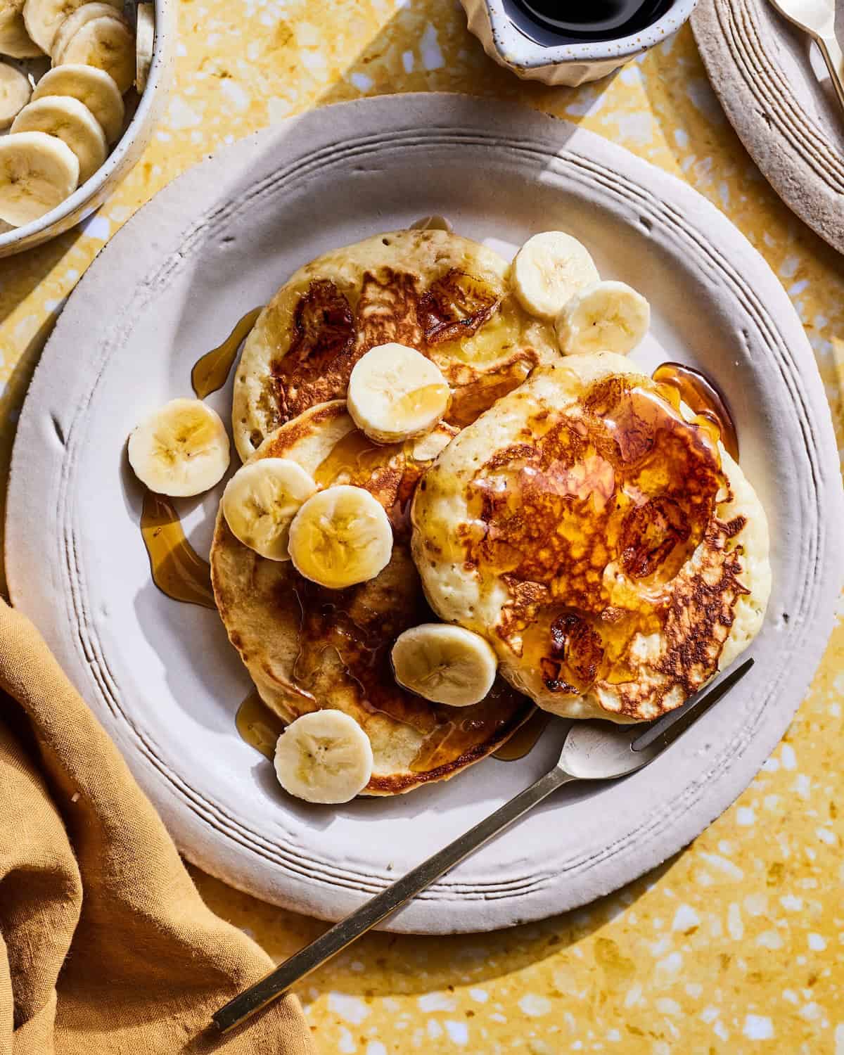 Banana Pancakes with maple syrup on a breakfast table