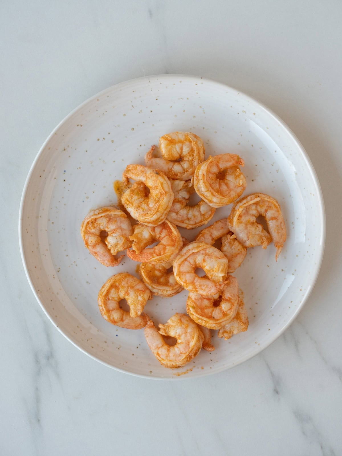 A plate with cooked shrimp.
