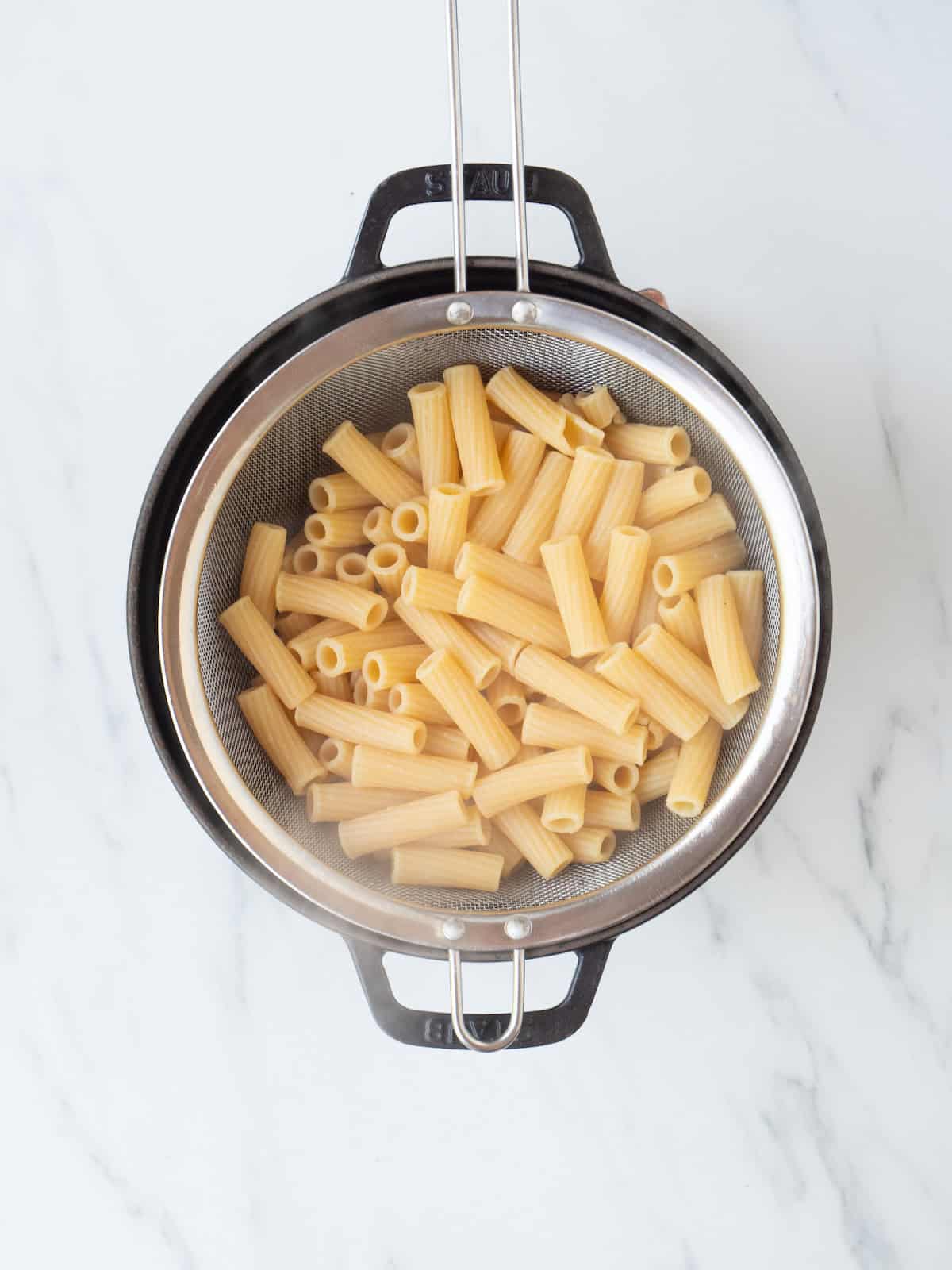 A pot with a sieve with boiled pasta.