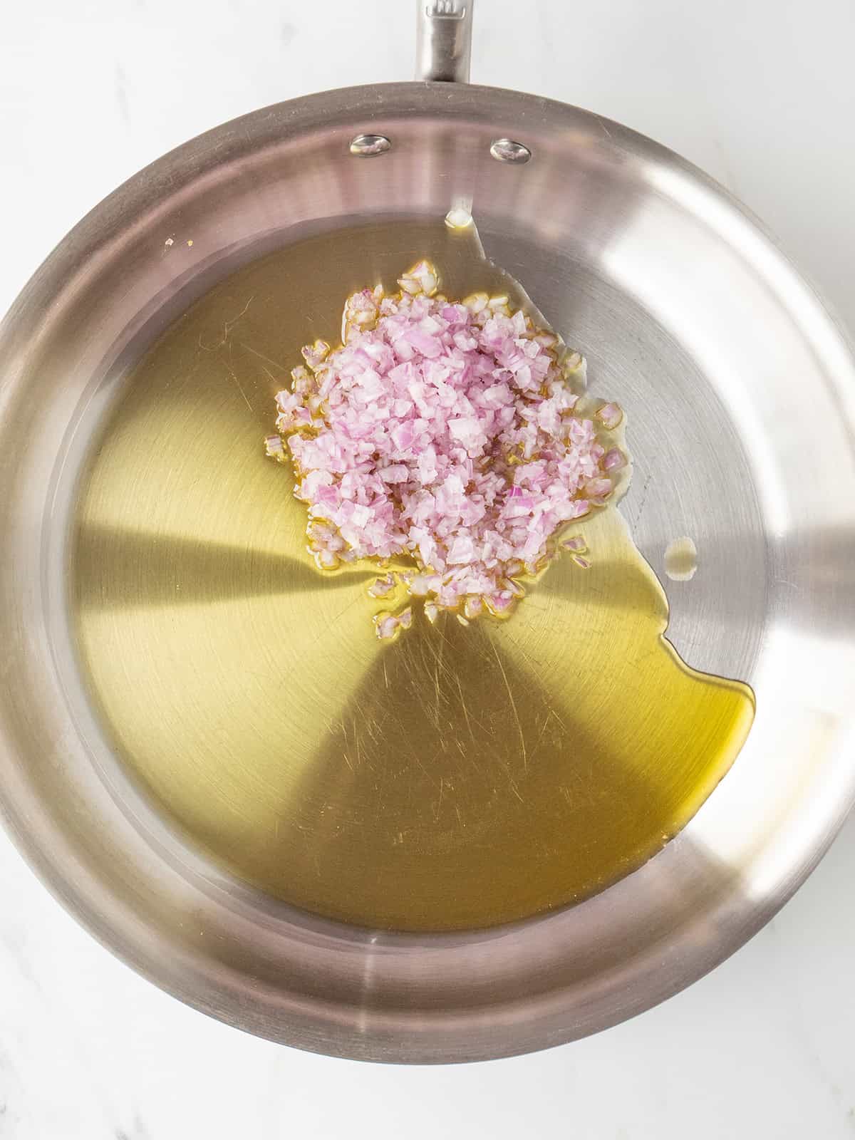 Chopped shallots in olive oil pan