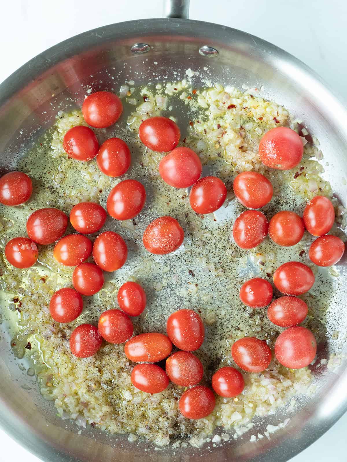 Cherry tomatoes sautéing in pan