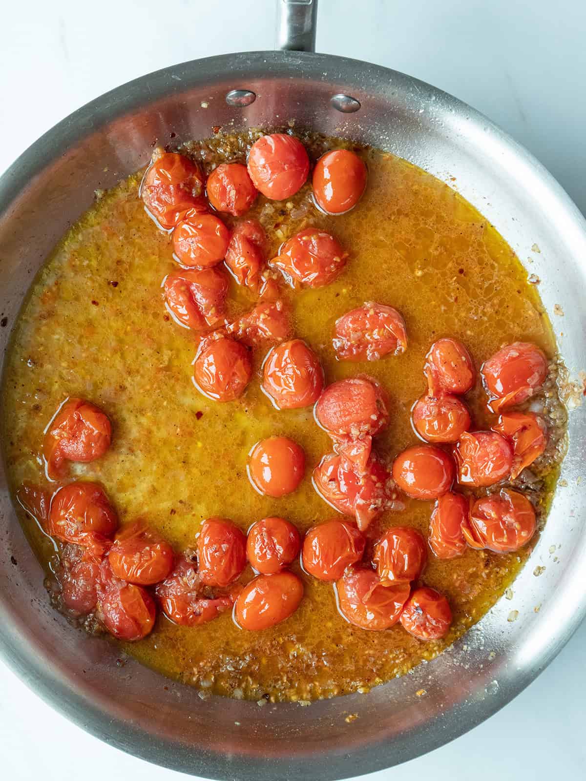 Cherry tomatoes and lobster meat in a skillet.
