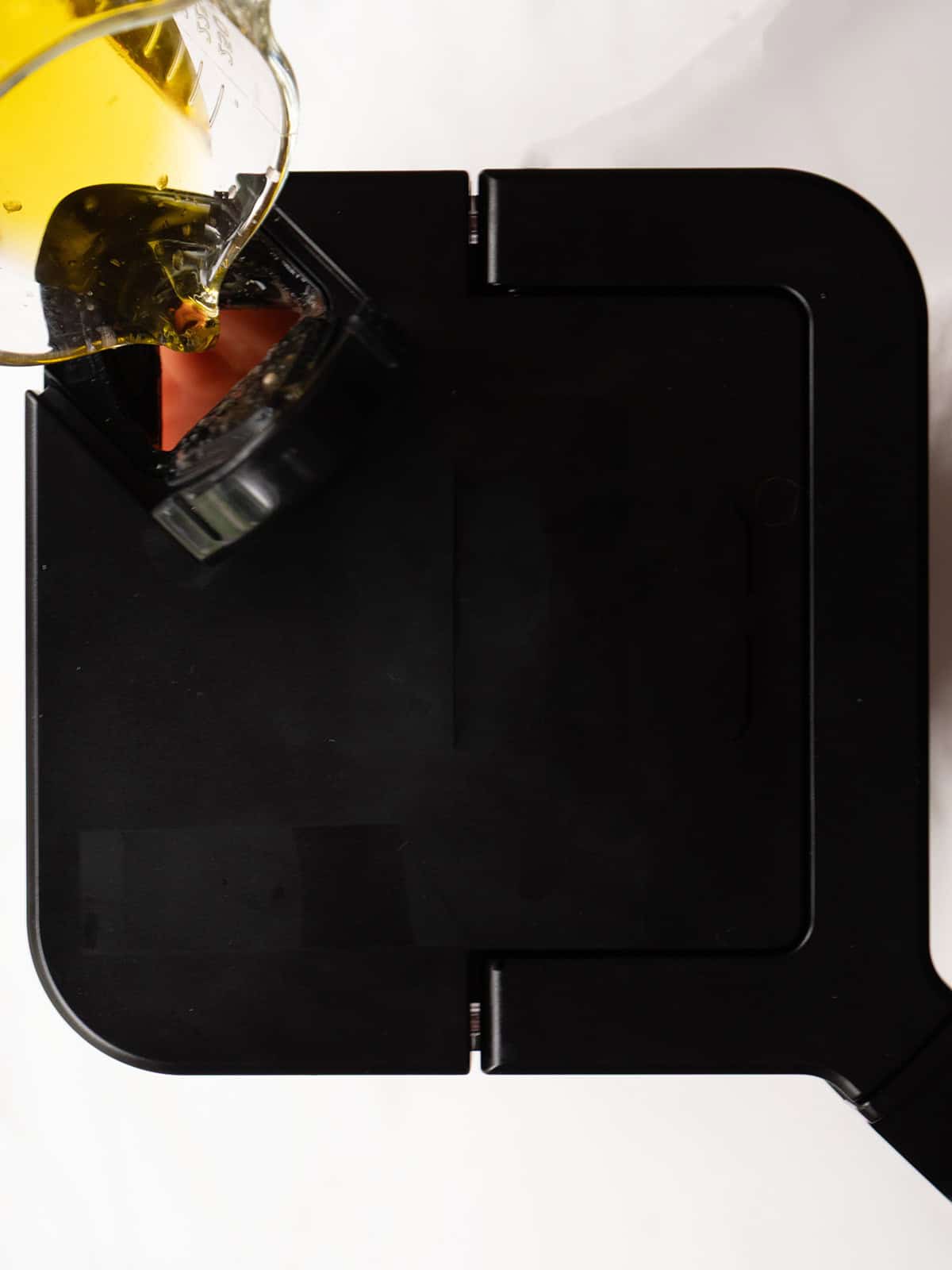 Pouring oil into a black container
