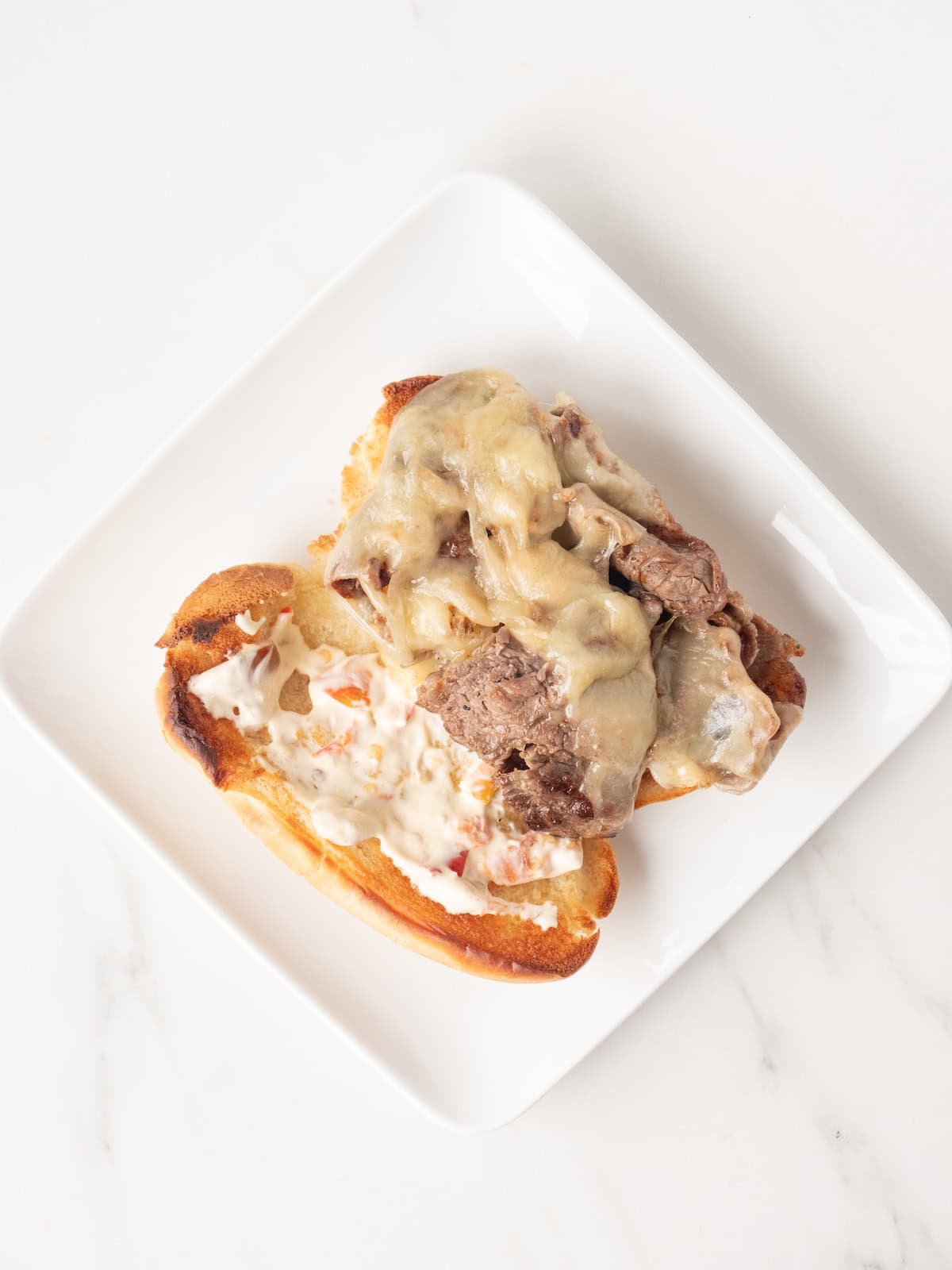 A plate with a philly cheesesteak.