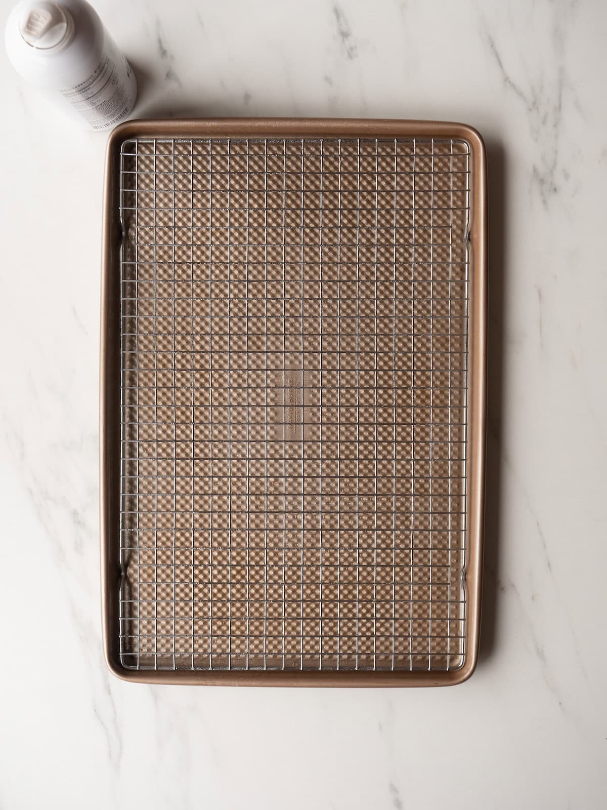 A baking sheet with a wire rack placed on it, and sprayed with nonstick cooking spray.