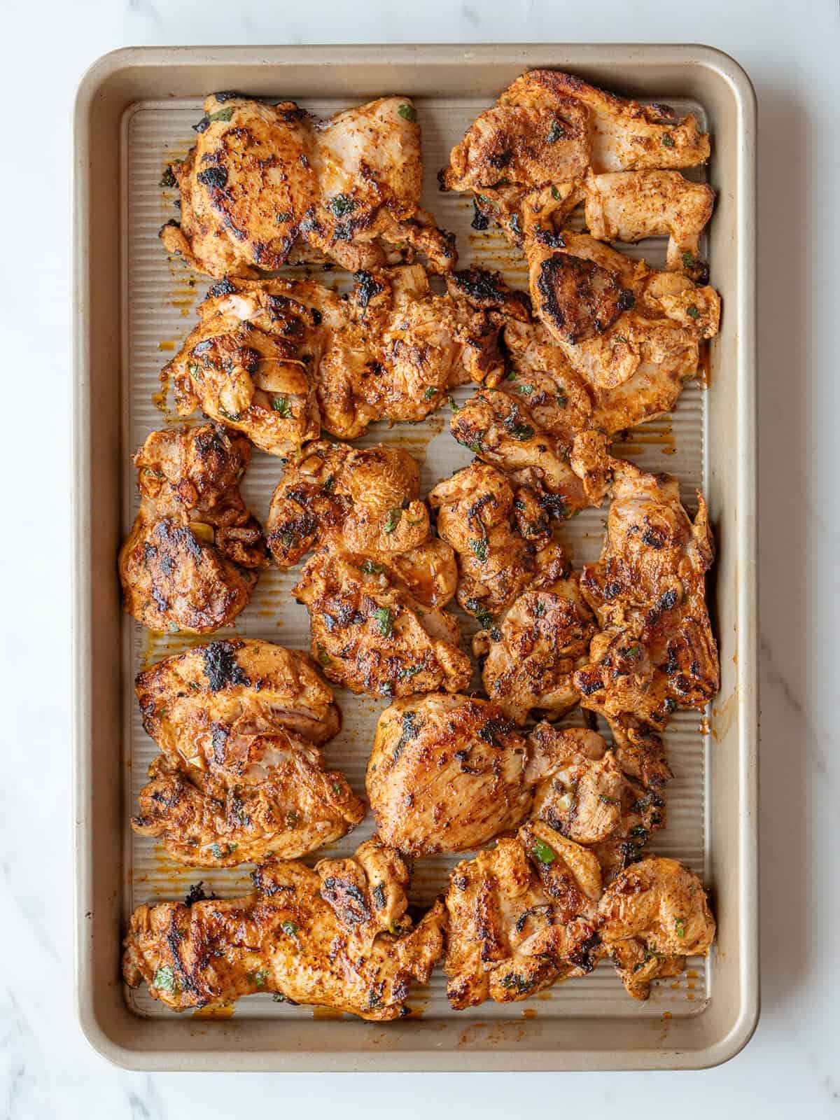 Grilled chicken thighs on baking tray