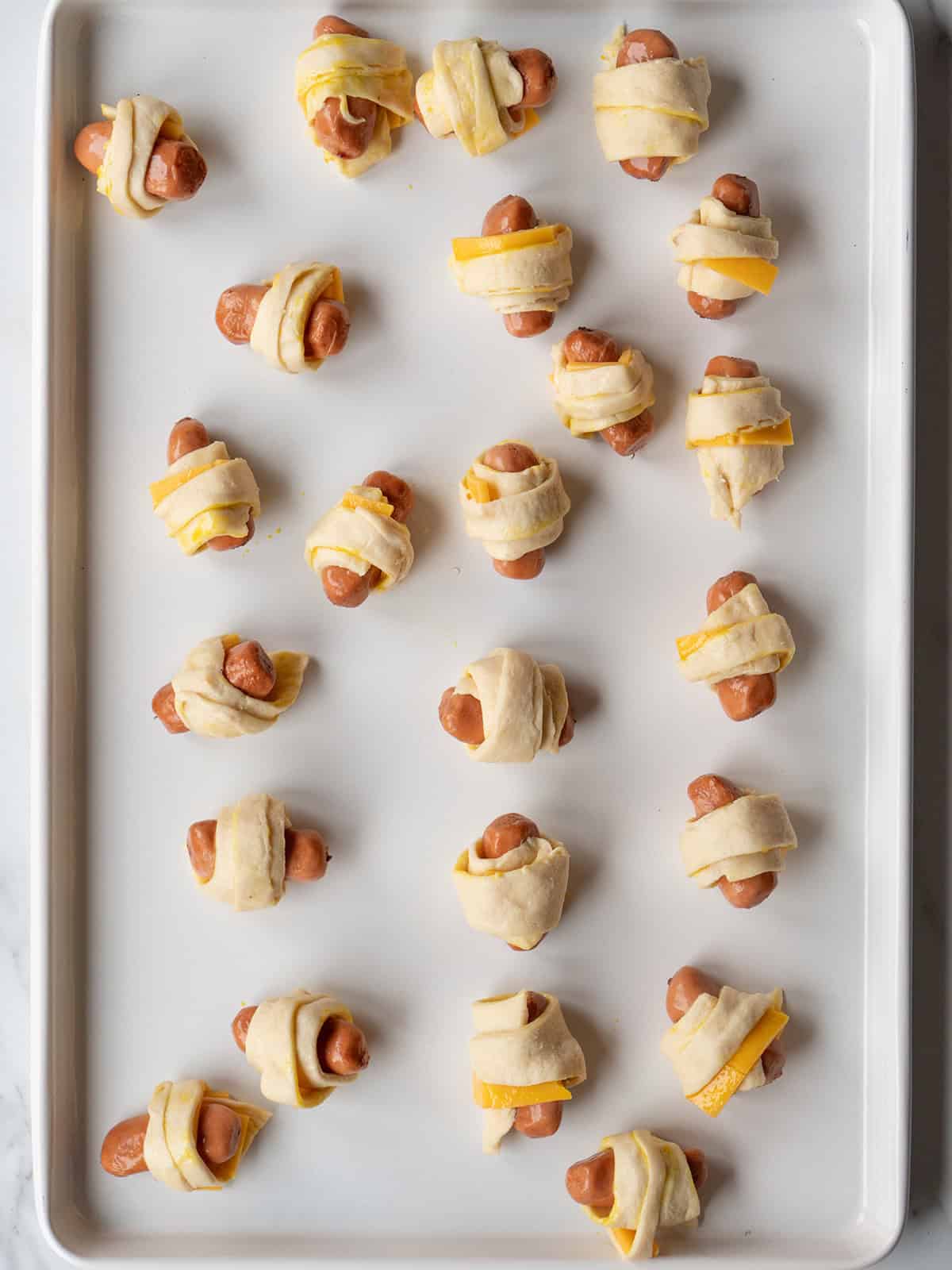 Cocktail sausages rolled with cheddar in crescent dough