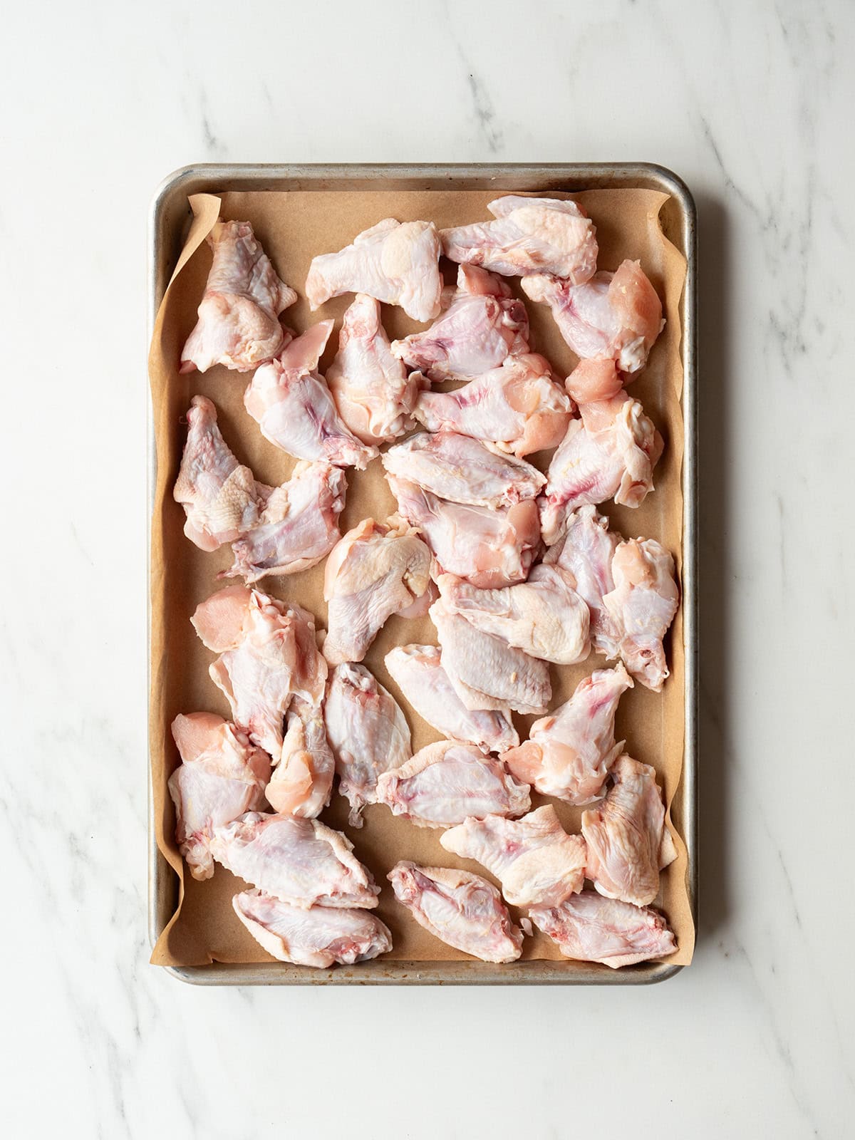 Raw chicken wings on baking tray