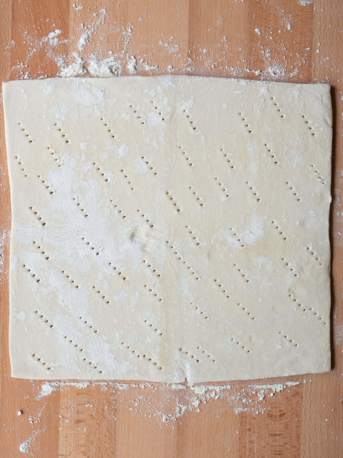 Rolled puff pastry dough on wooden surface