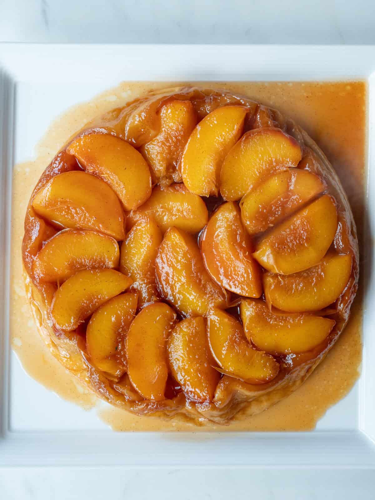 Caramelized peach tarte tatin on a white plate