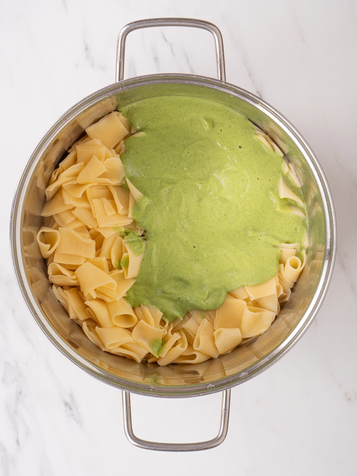 Cooked pasta with the blended zucchini sauce in a large pot