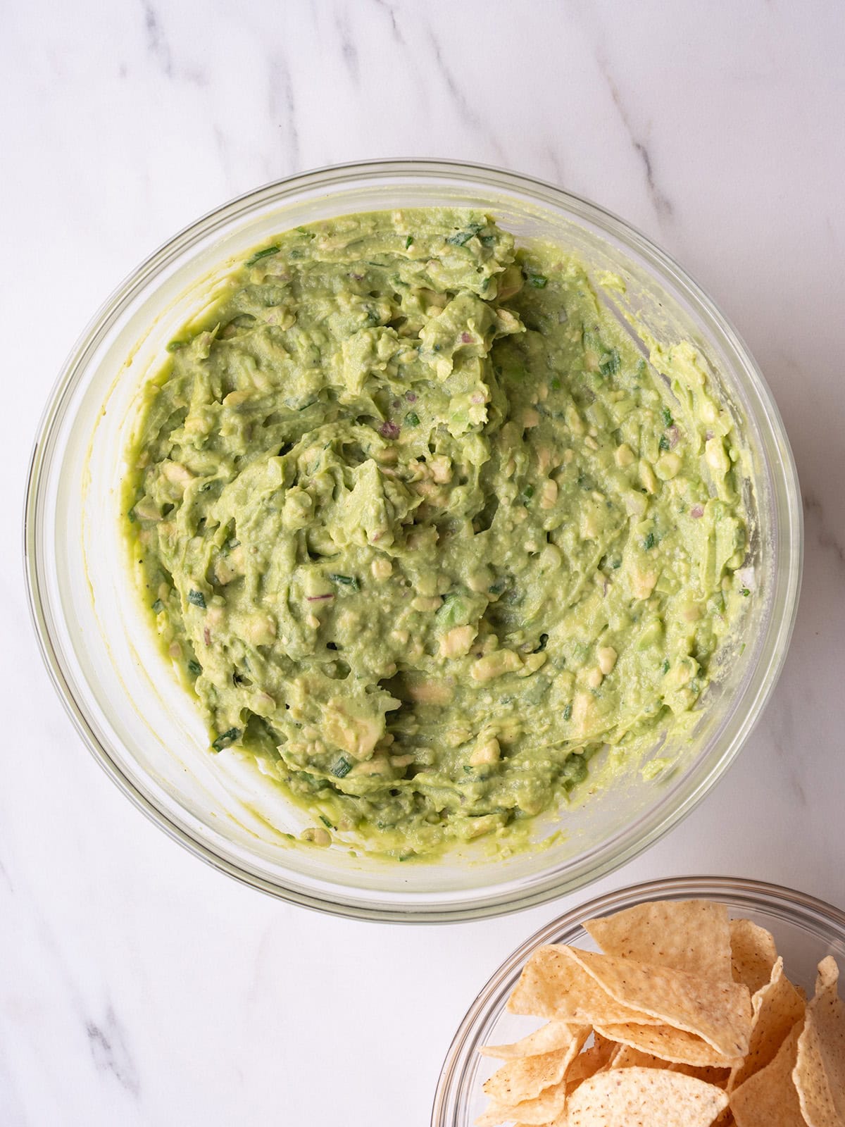 Guacamole in a bowl with chips on the side