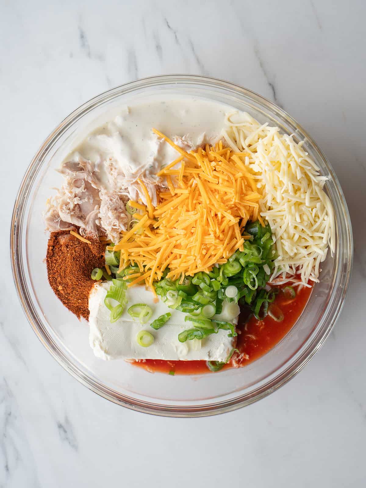 Ingredients for buffalo chicken dip in a bowl