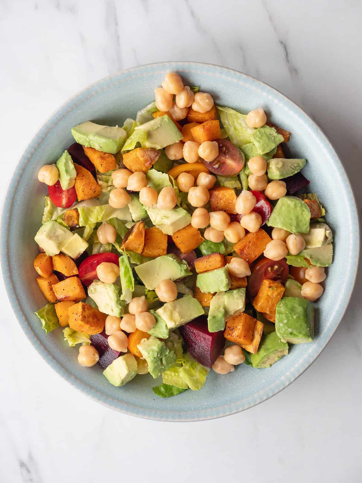 Lettuce topped with sweet potatoes, beets, cherry tomatoes, avocados and chickpeas for the California Cobb Salad