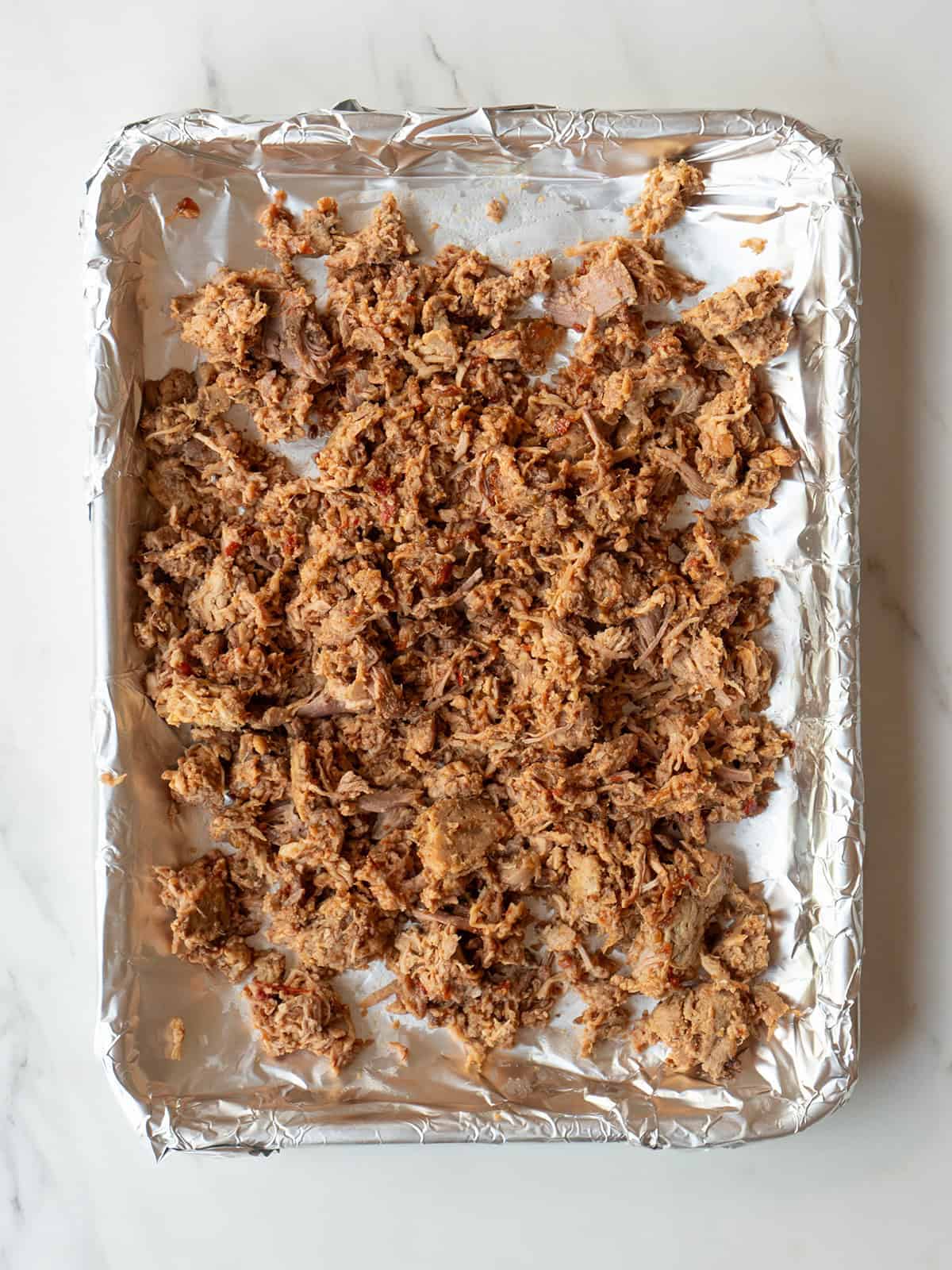 Shredded carnitas on a baking sheet