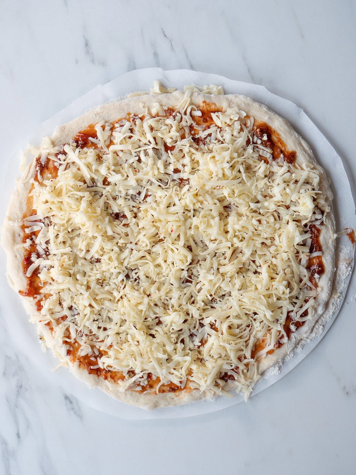 Pizza dough topped with salsa and cheese