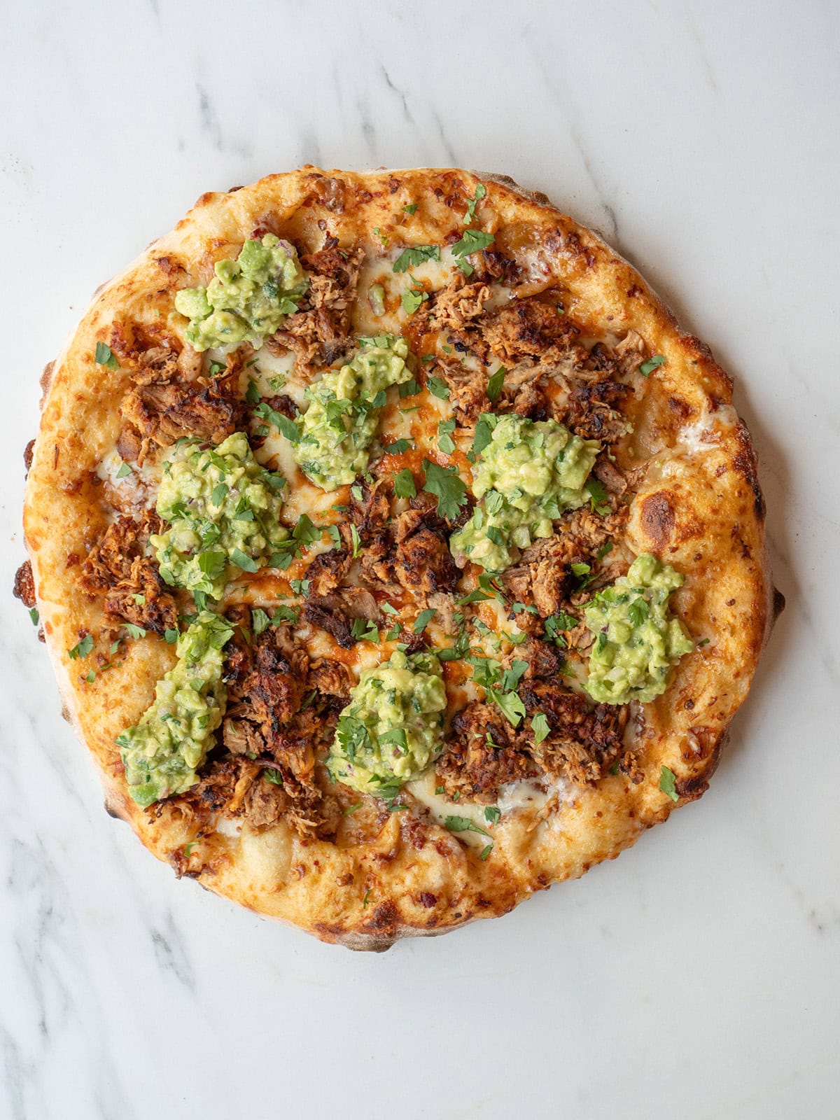 Pizza topped with Carnitas and Guacamole