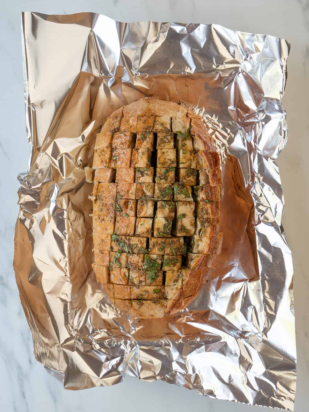 Olive oil and spice mixture in the crevices of the sliced Italian Bread