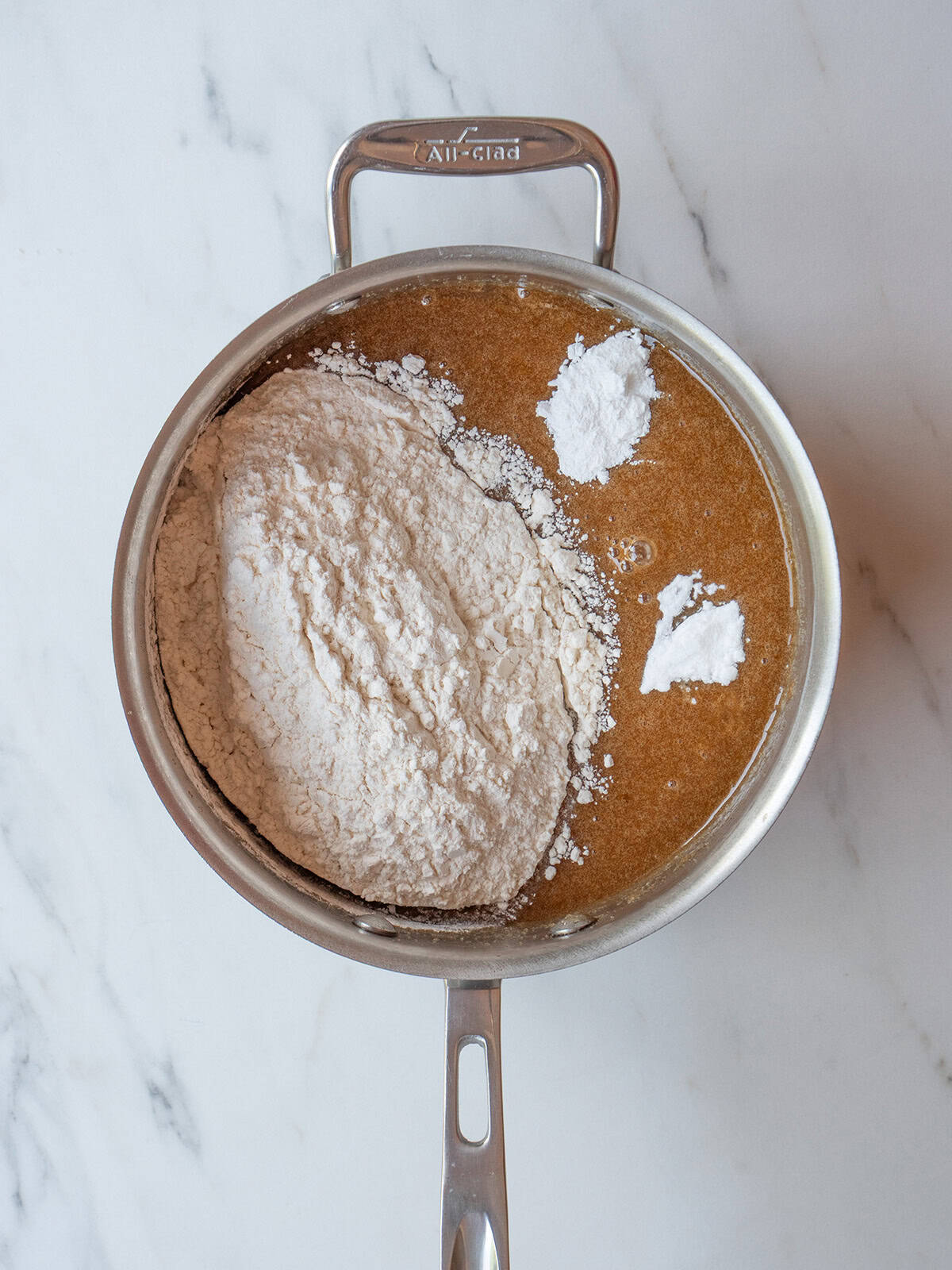 Dry ingredients added into the pot of mixed butter, sugar and vanilla