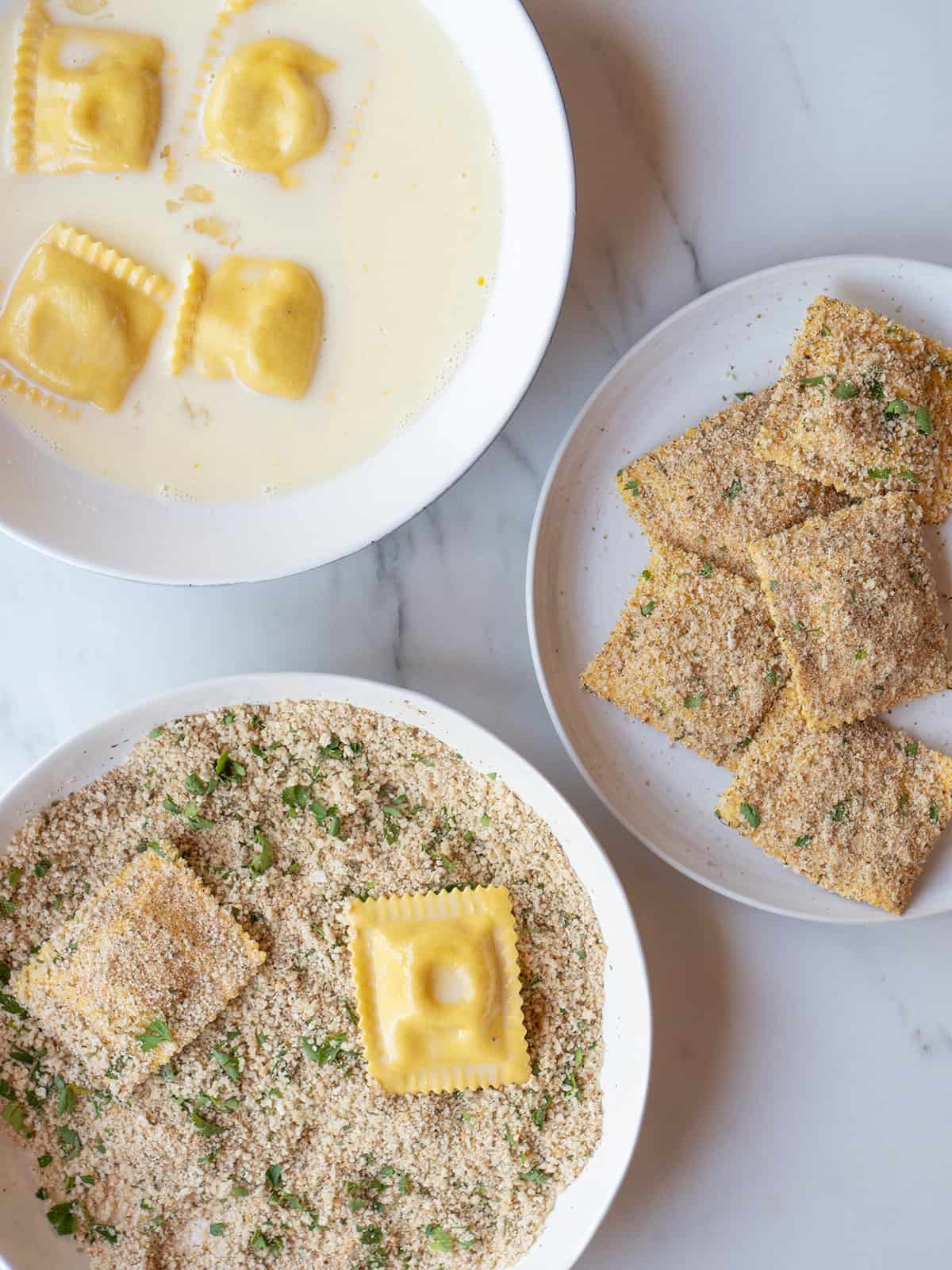 Ravioli being coated with egg and milk mixture and breaded with panko mixture for fried ravioli