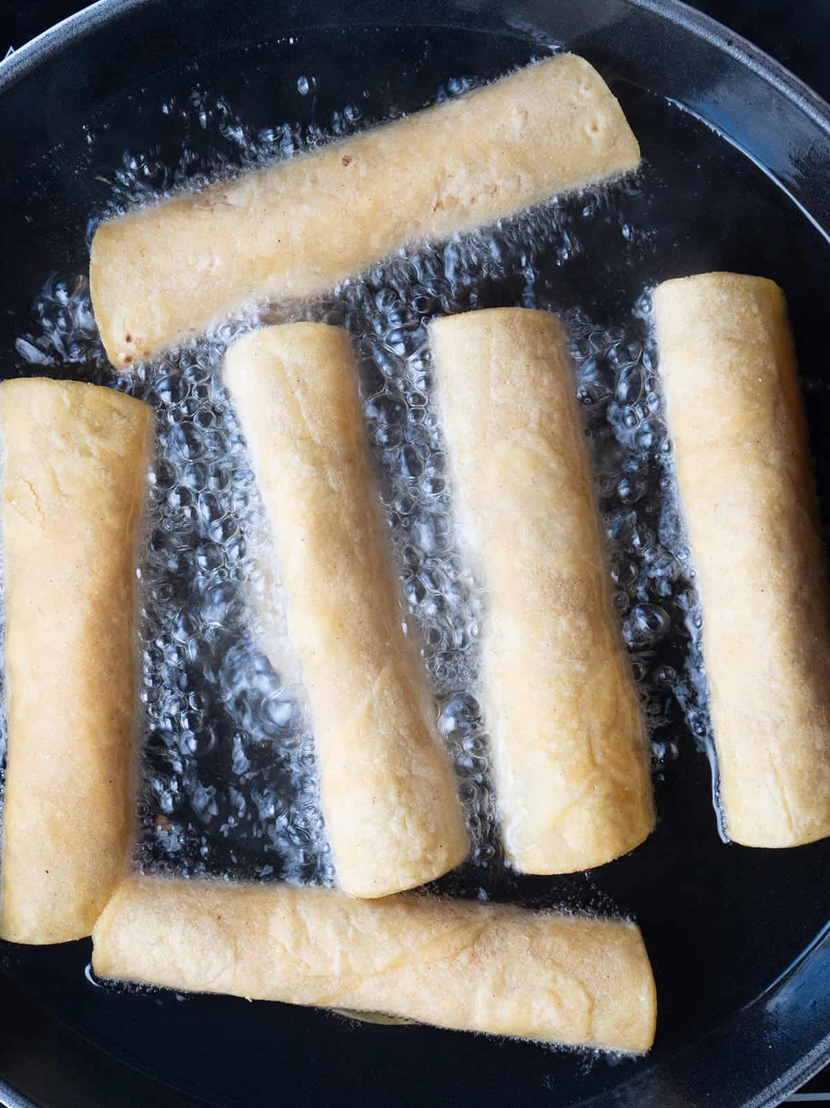 Homemade Chicken Taquitos being fried in oil