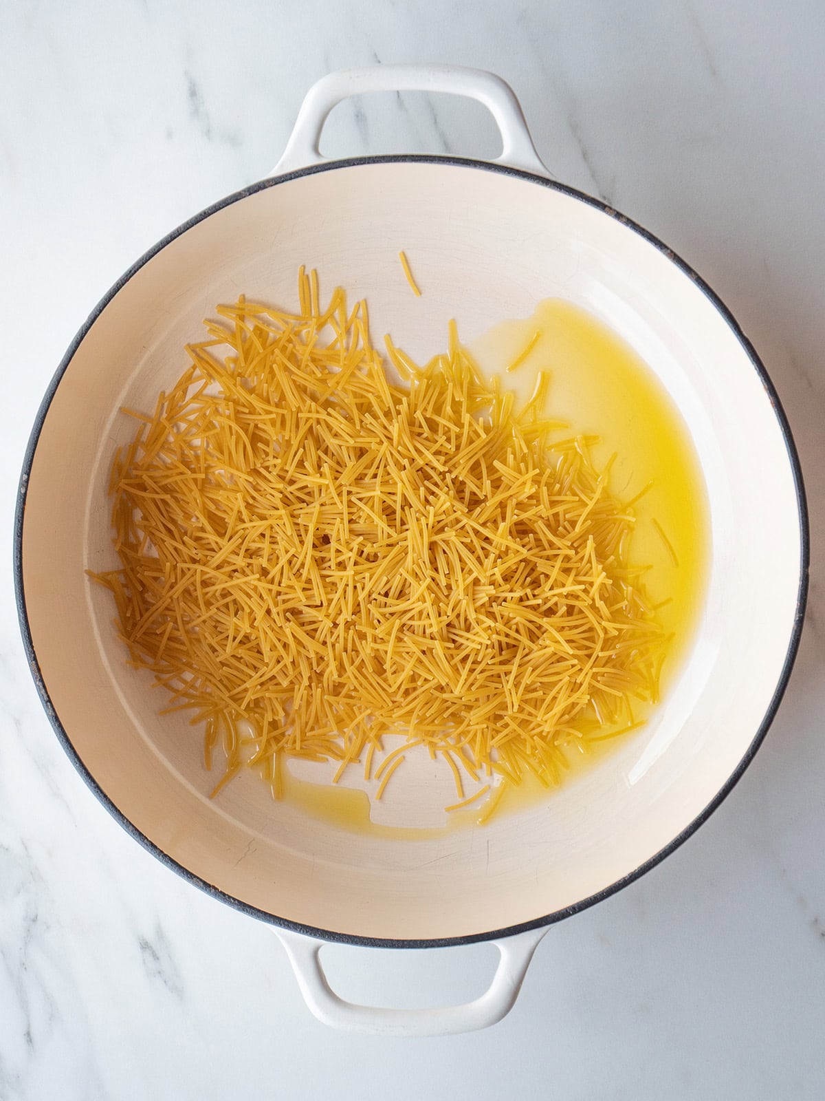 Pasta and oil in a large dutch oven for Sopa de Fideo