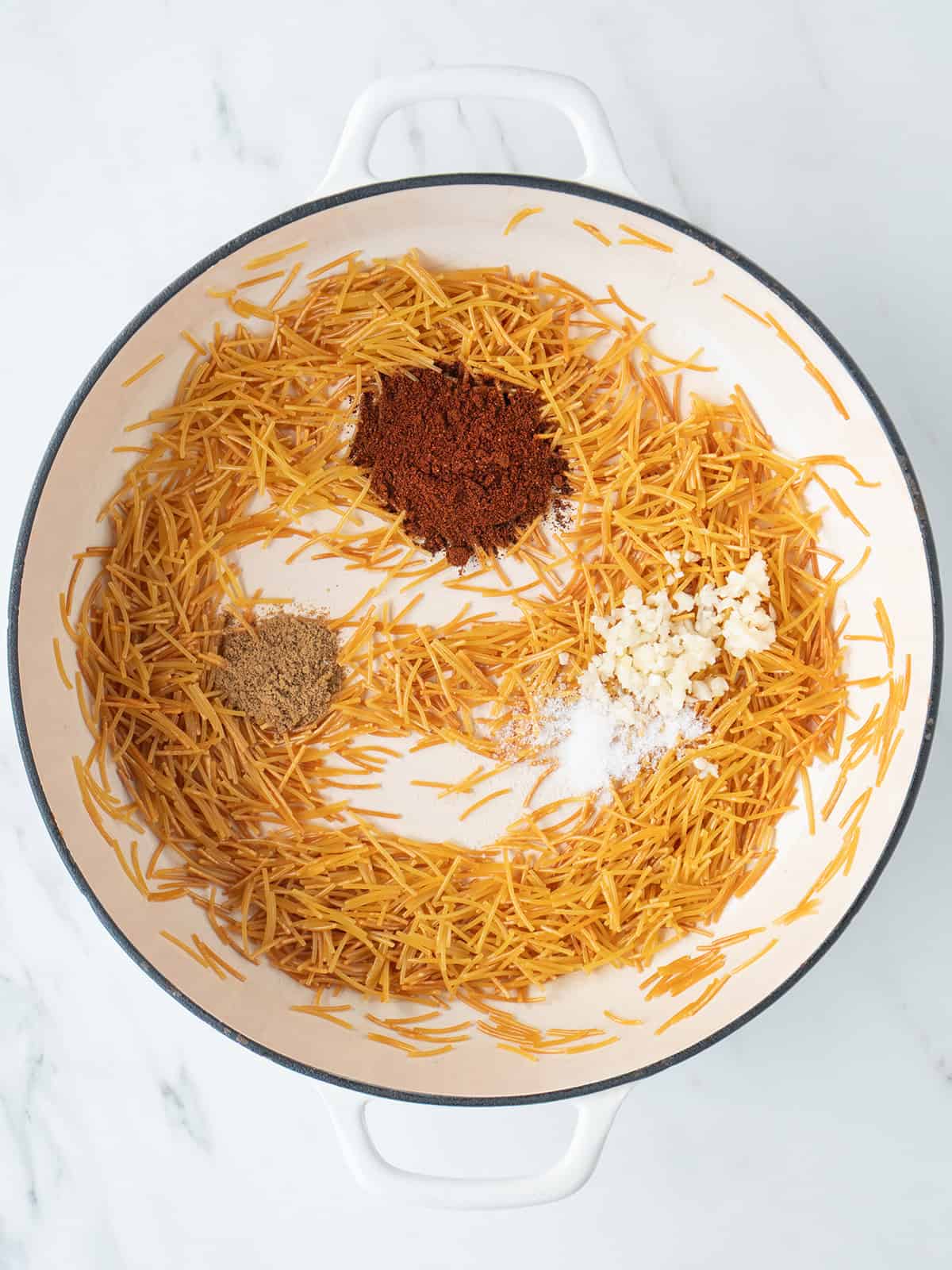 Pasta and spices in a large dutch oven for Sopa de Fideo