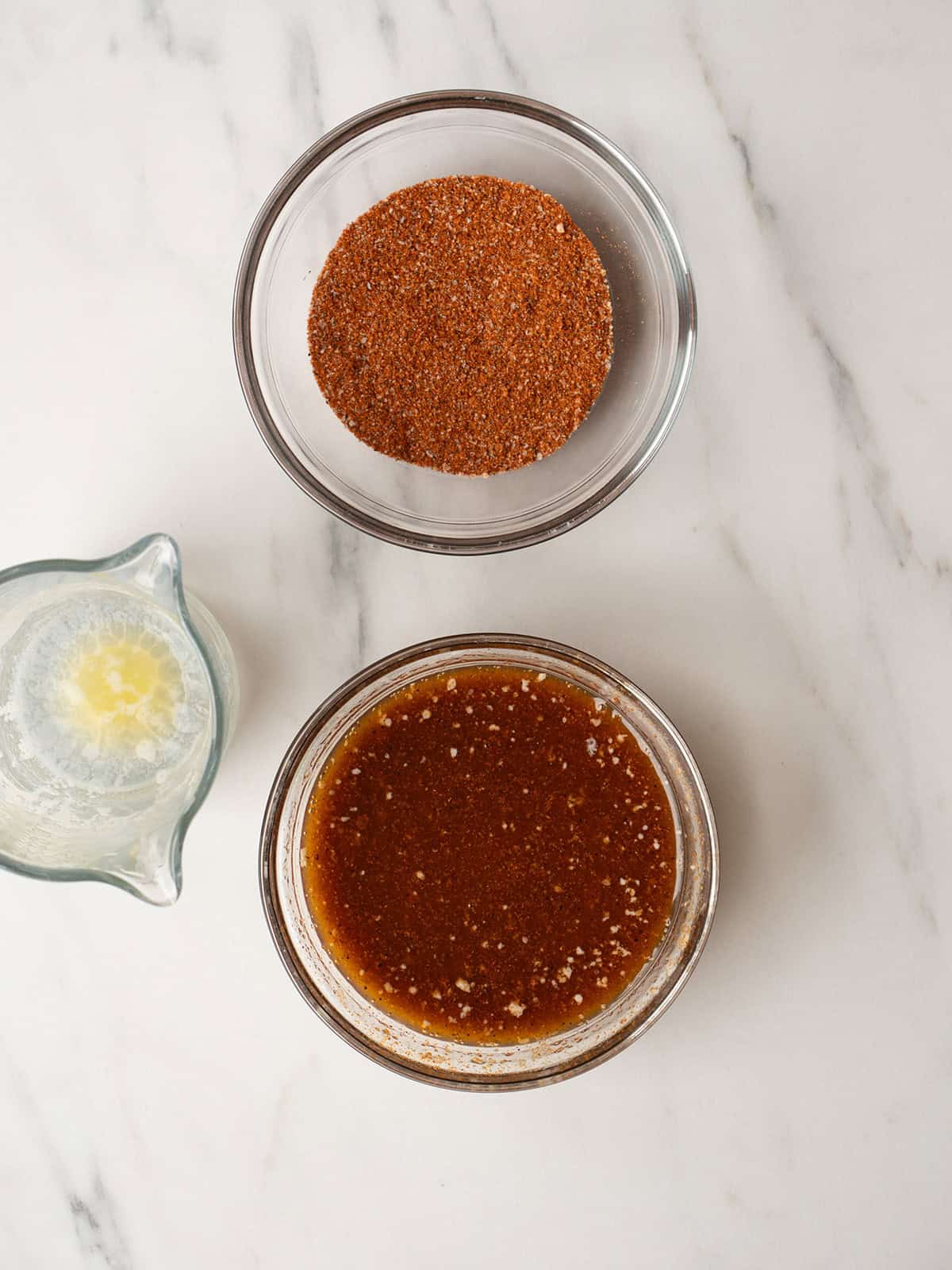 Spice and butter mix for the rotisserie chicken in a bowl with remaining spice in a separate bowl