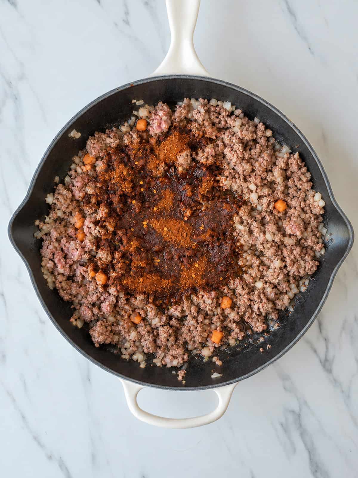 Seasoned ground beef and diced sweet potato cooking in a skillet for Crispy Ground Beef Tacos.