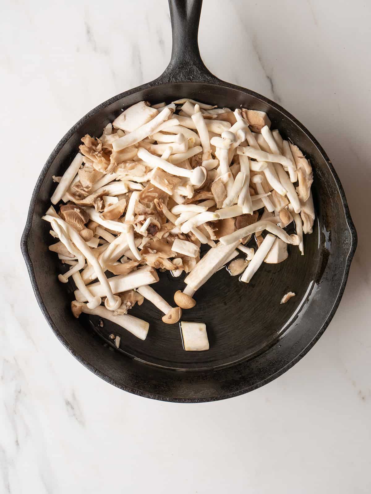 Sliced mushrooms in a cast iron skillet