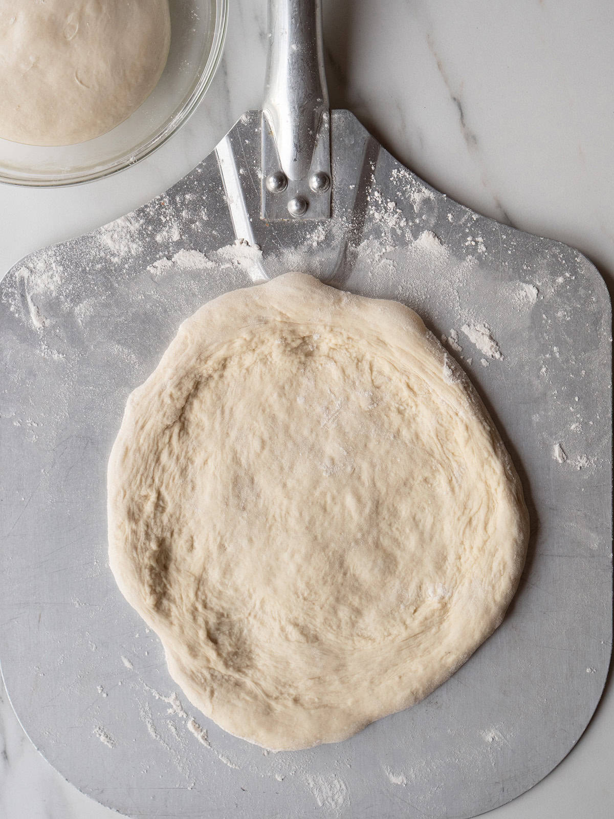 Pizza dough on a metal peel