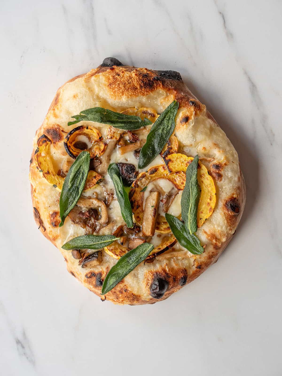 Pizza topped with squash and mushrooms