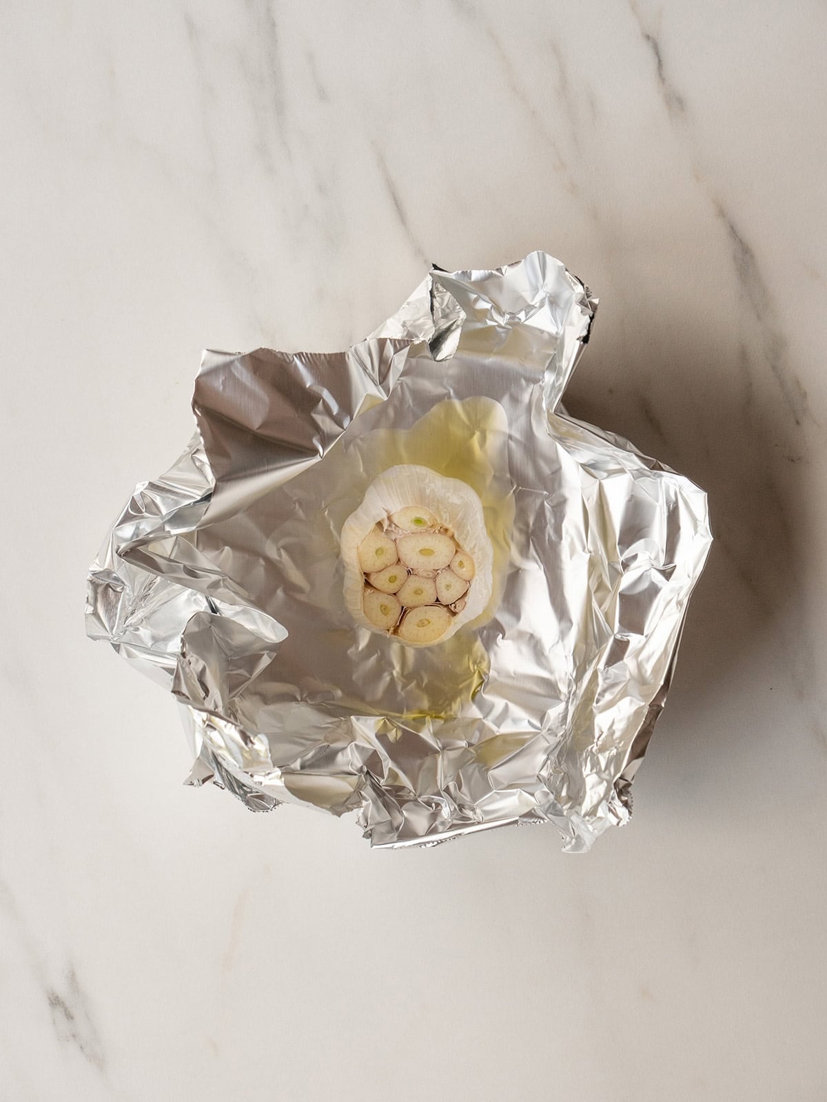 Garlic bulb wrapped in aluminum foil