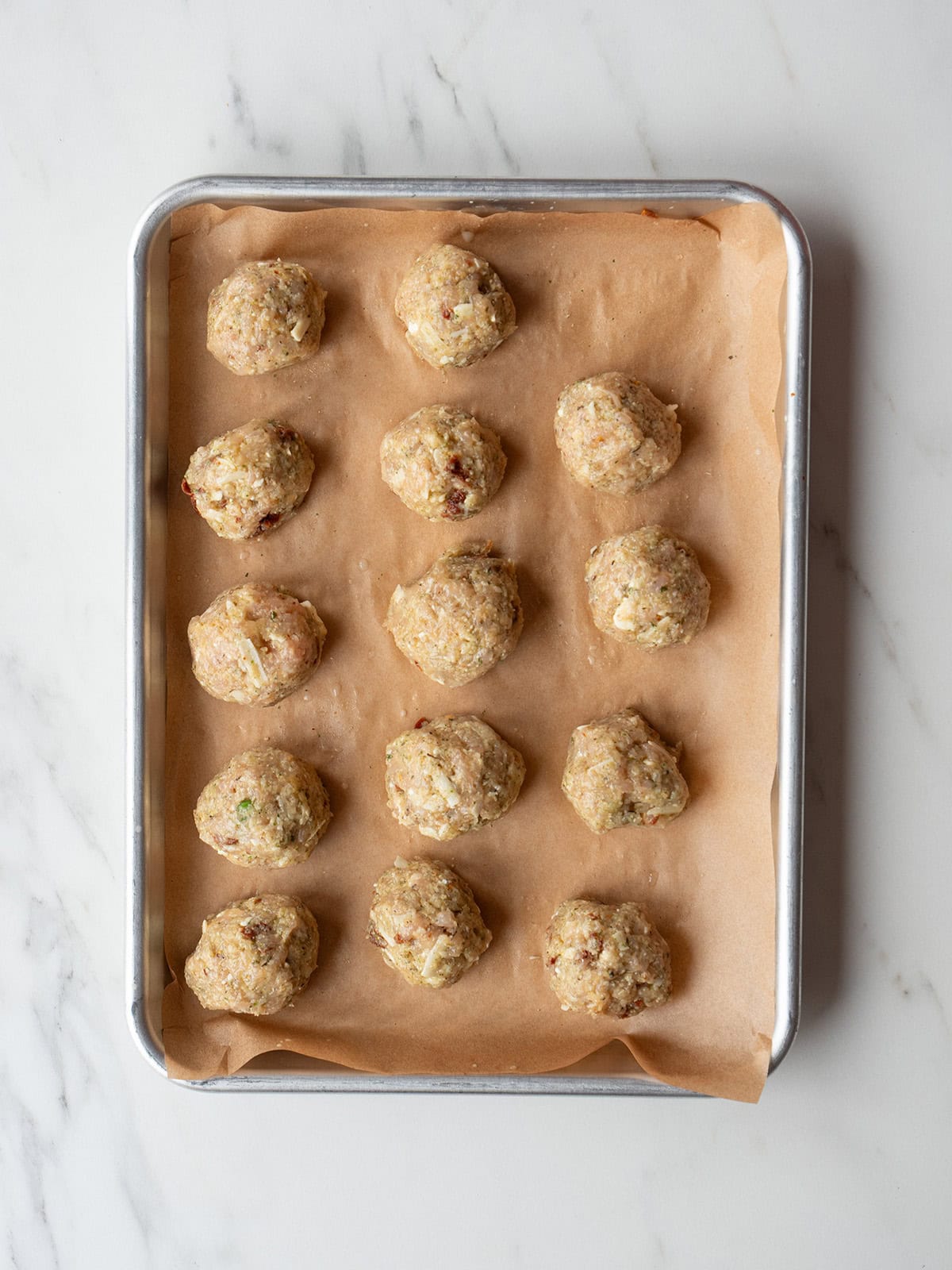 Raw meatballs on a baking tray