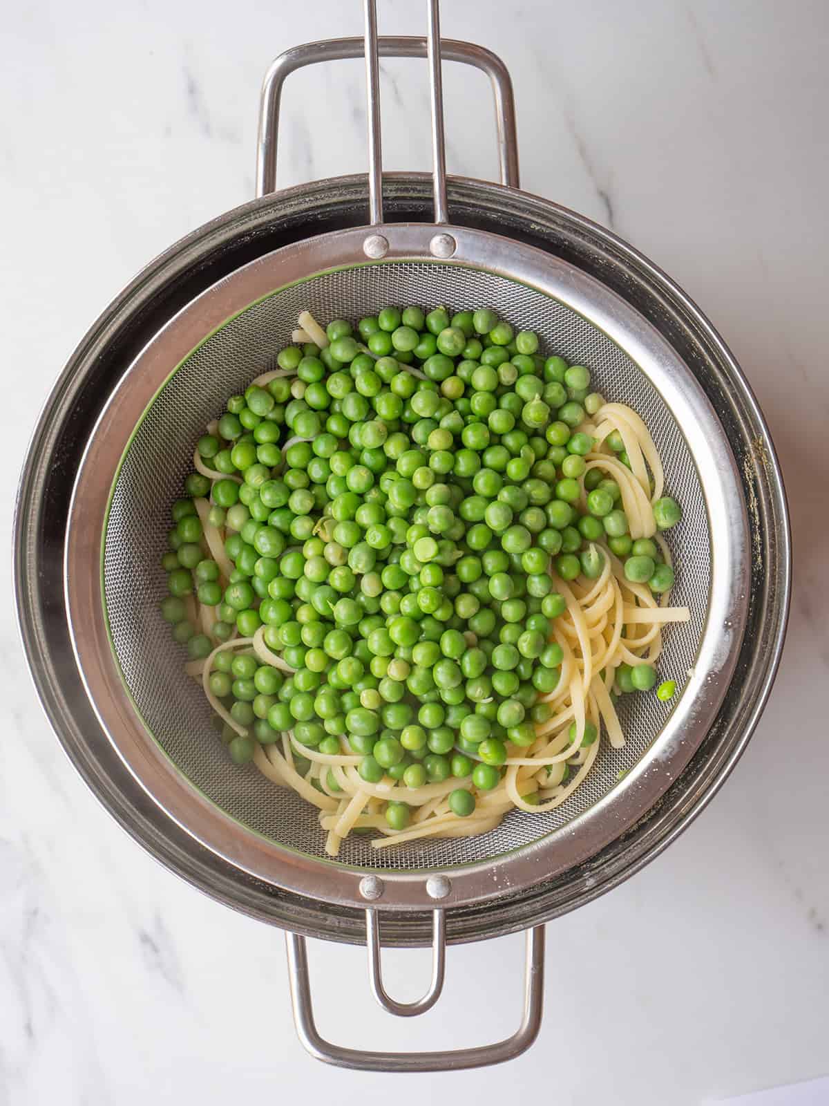 Pasta and green peas in strainer