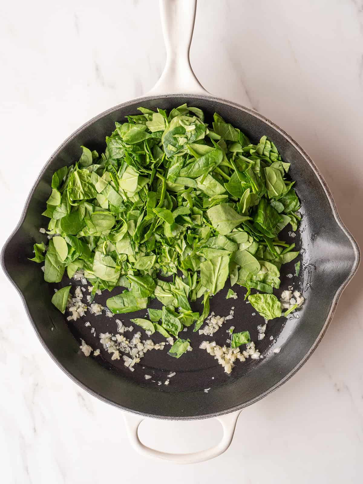 Fresh spinach and garlic in skillet