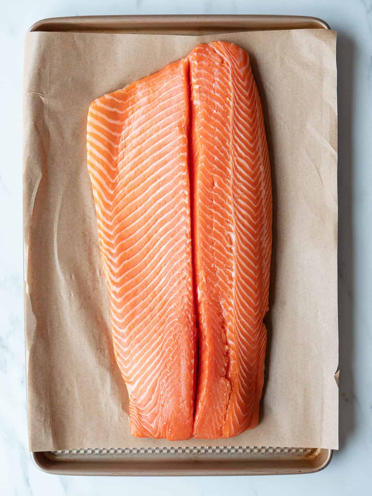 Raw salmon fillet on parchment paper