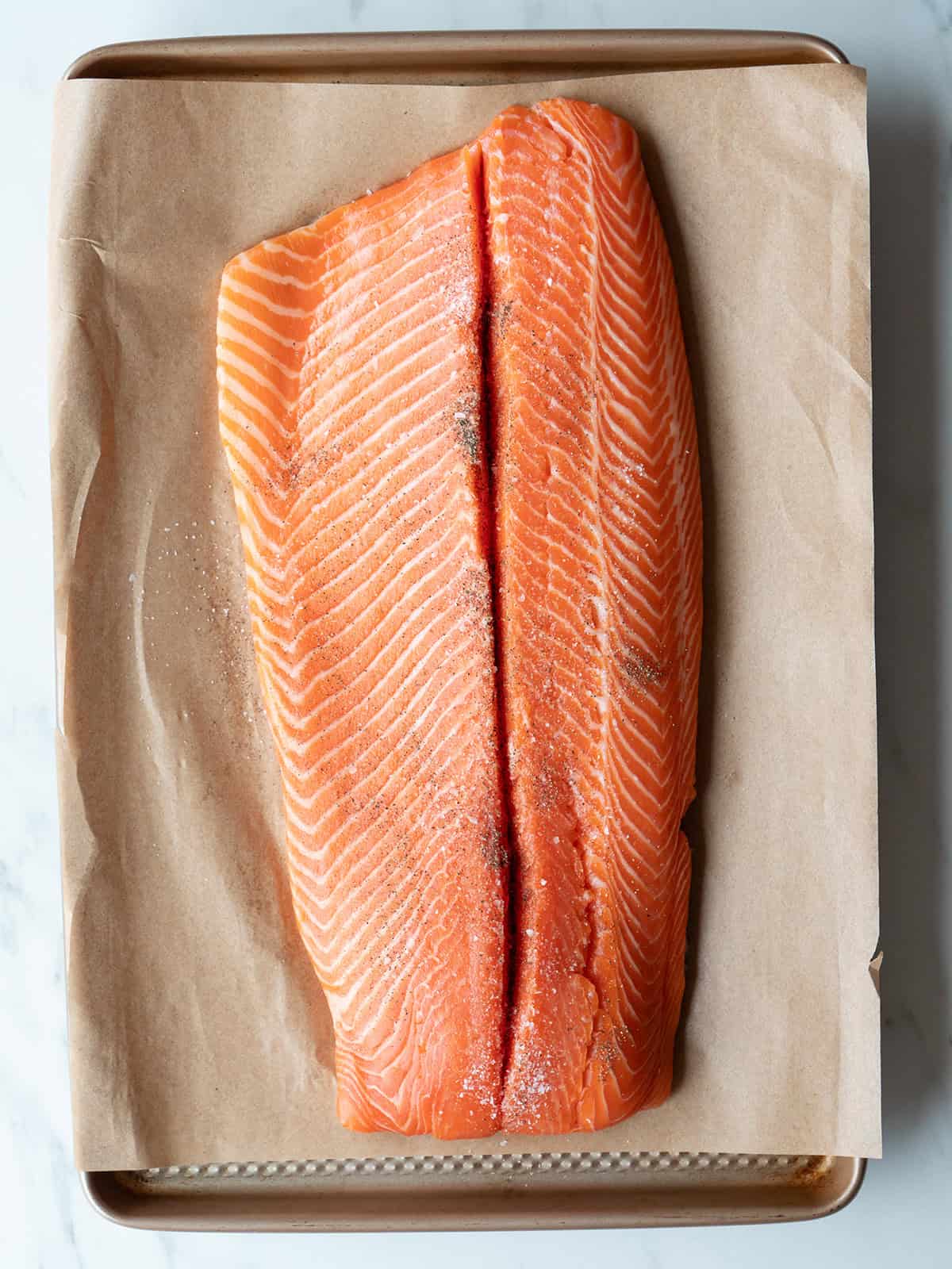 Raw salmon fillet on parchment paper