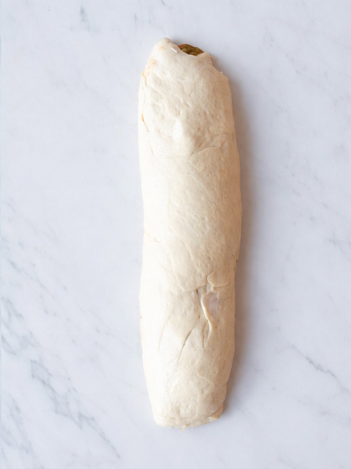Unbaked rolled dough on marble surface
